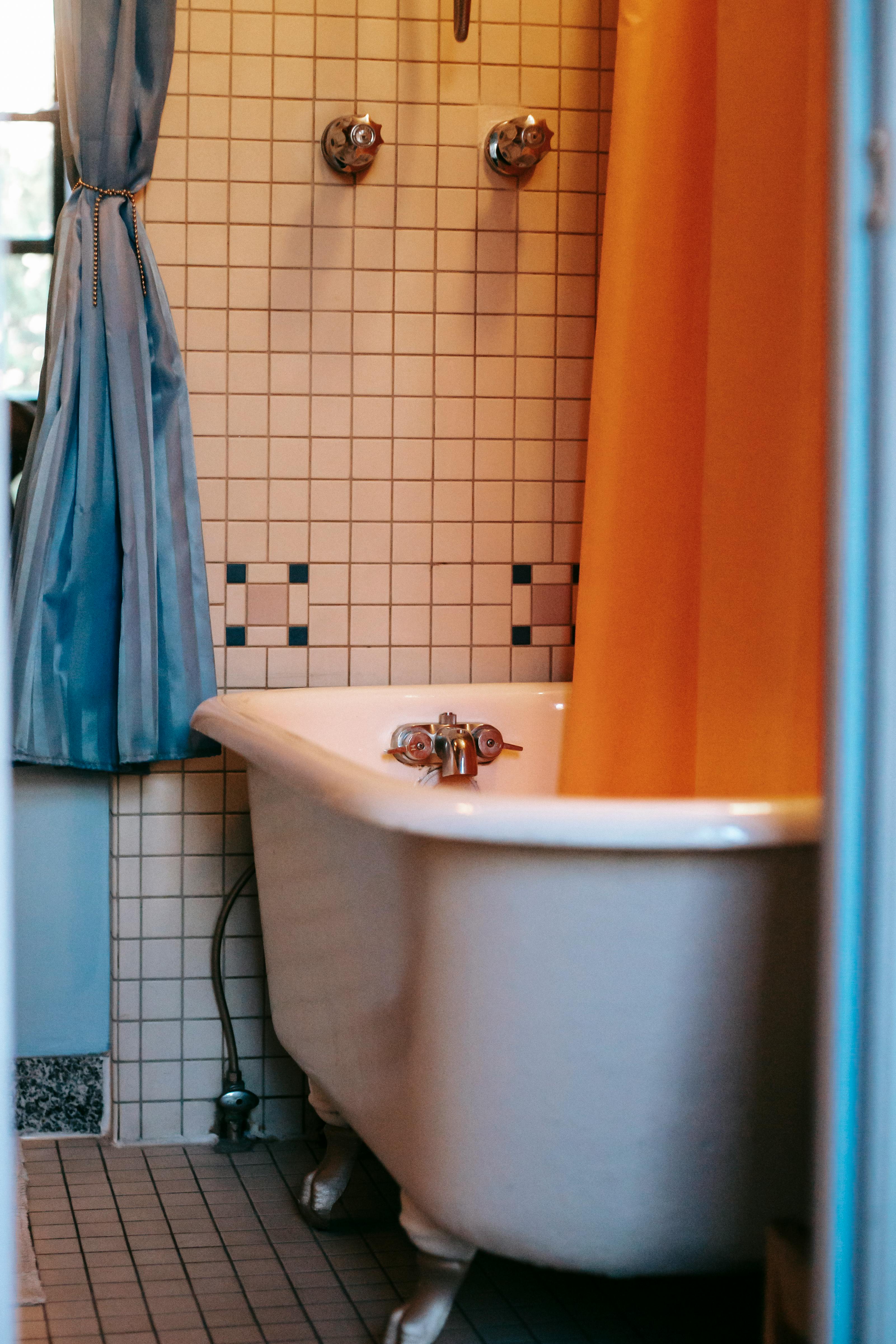 An orange shower curtain in a bathroom | Source: Pexels