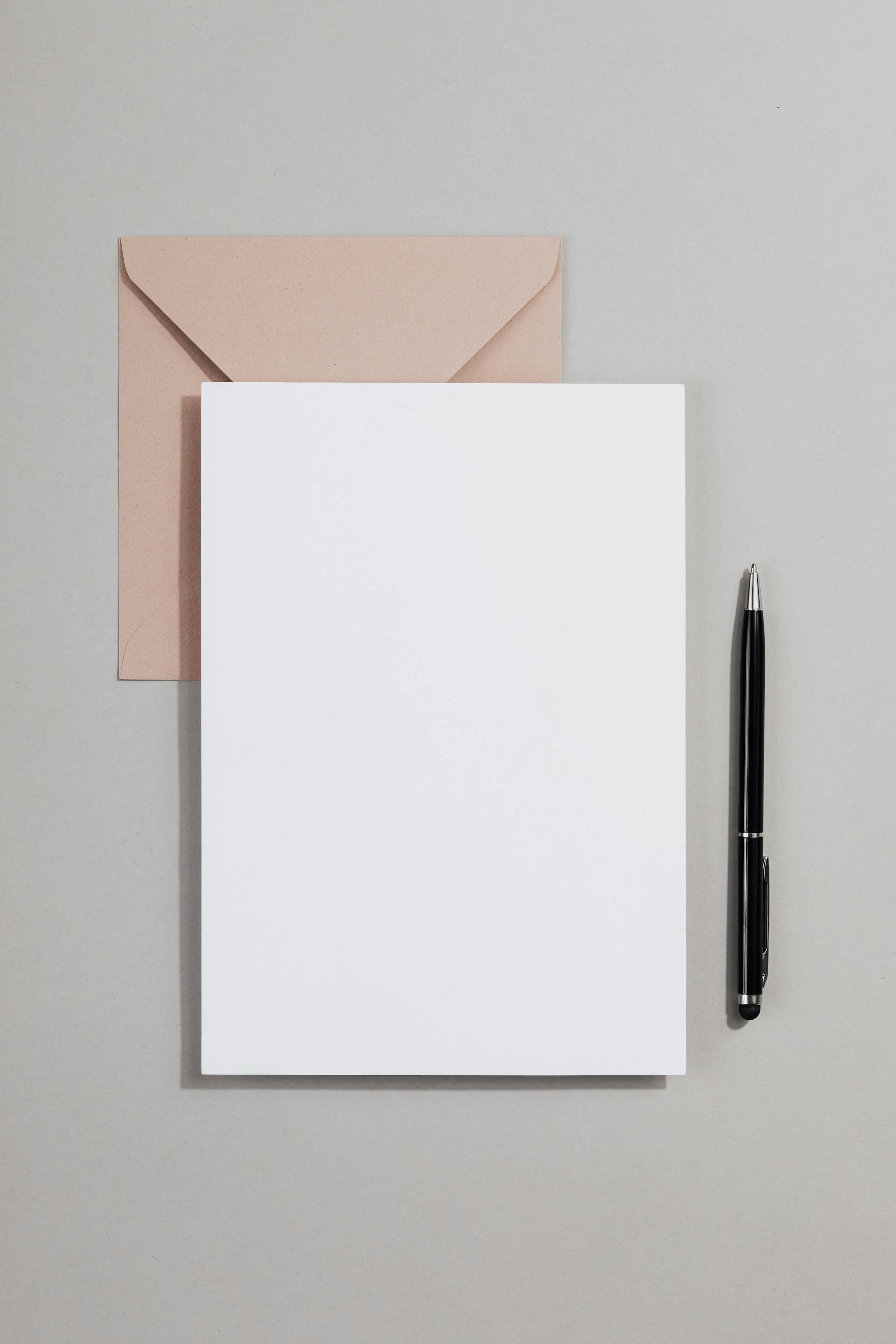 A notepad, pen, and envelope | Source: Pexels