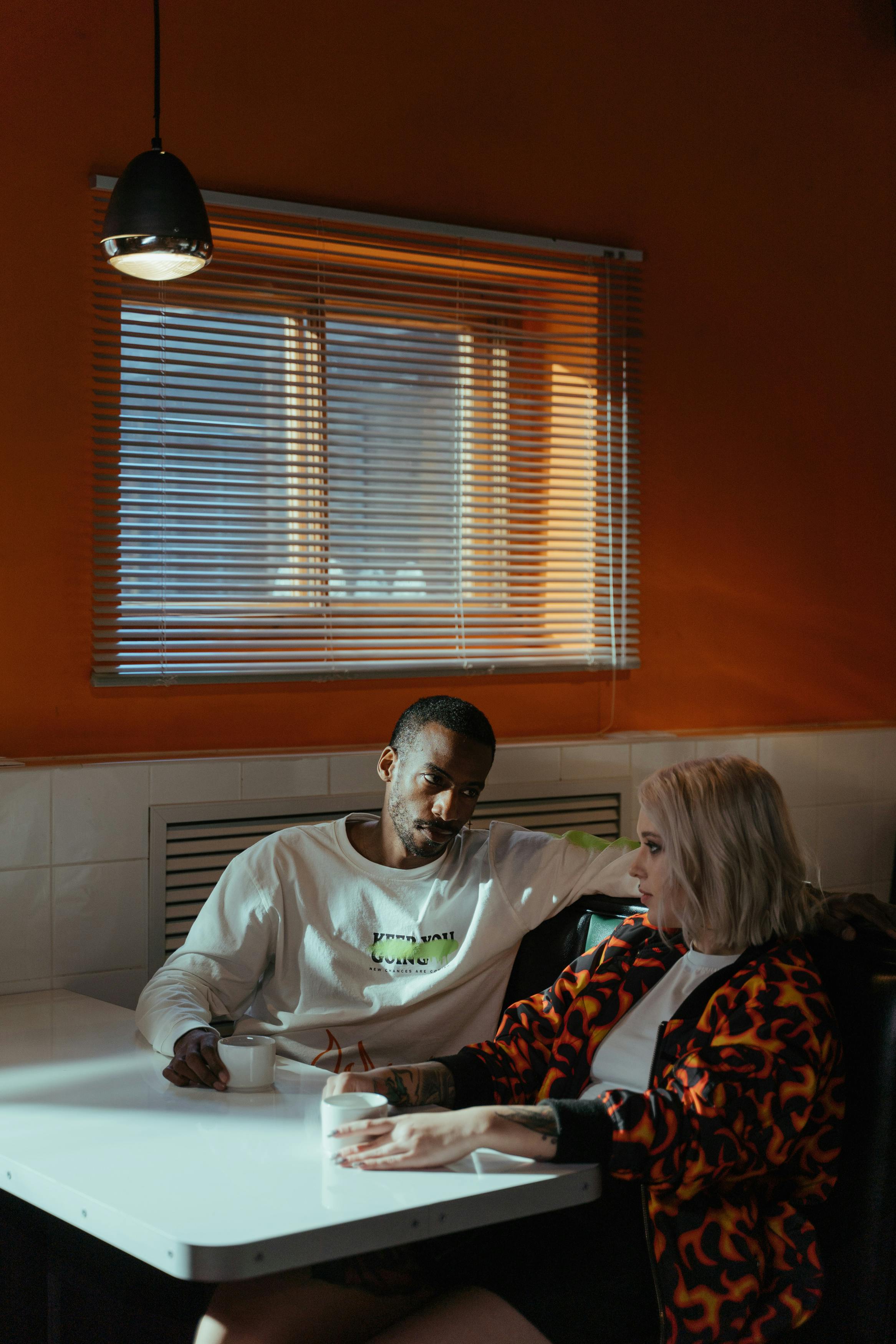 A man and a woman having coffee while talking | Source: Pexels