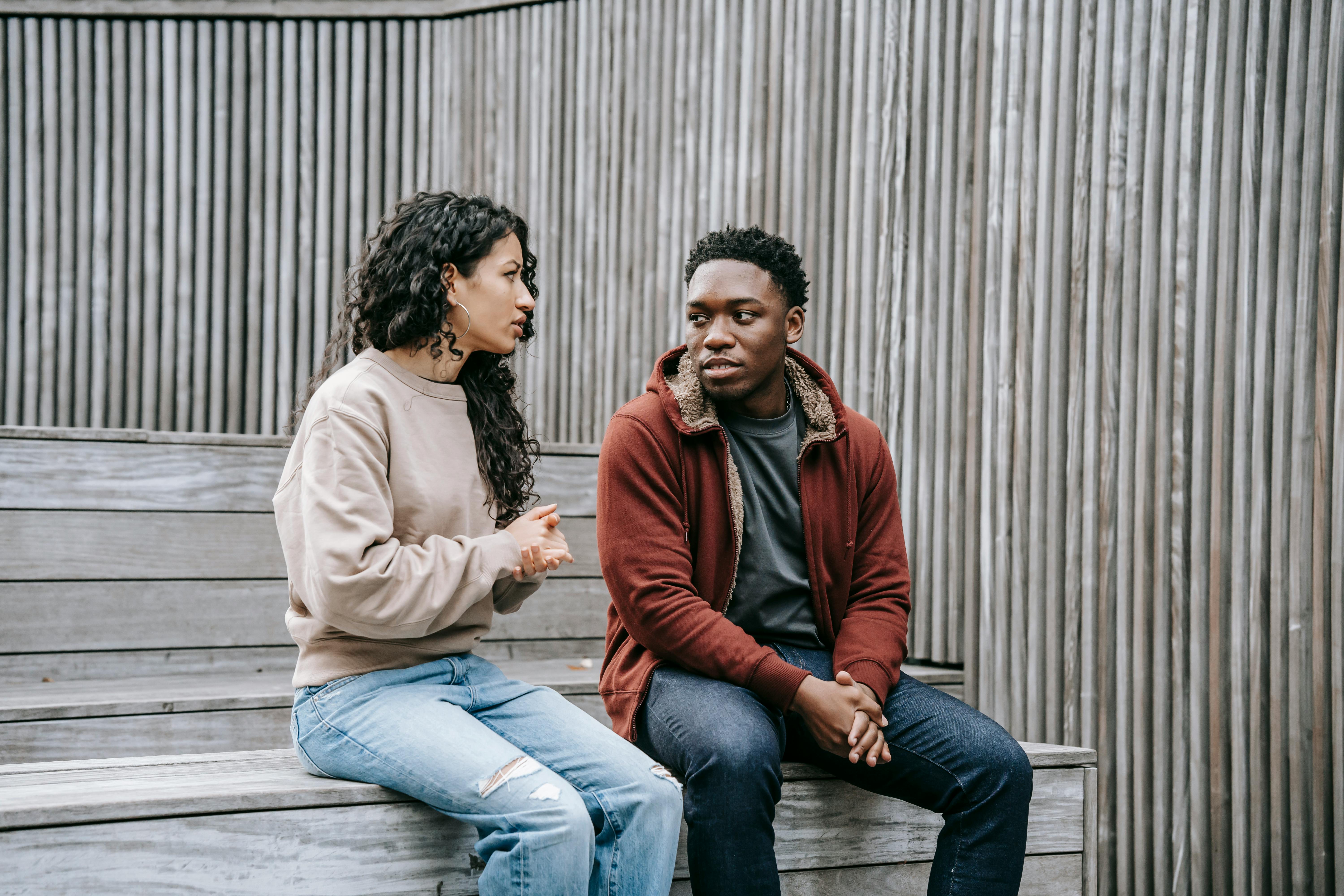A couple having a conversation while sitting on the stairs | Source: Pexels