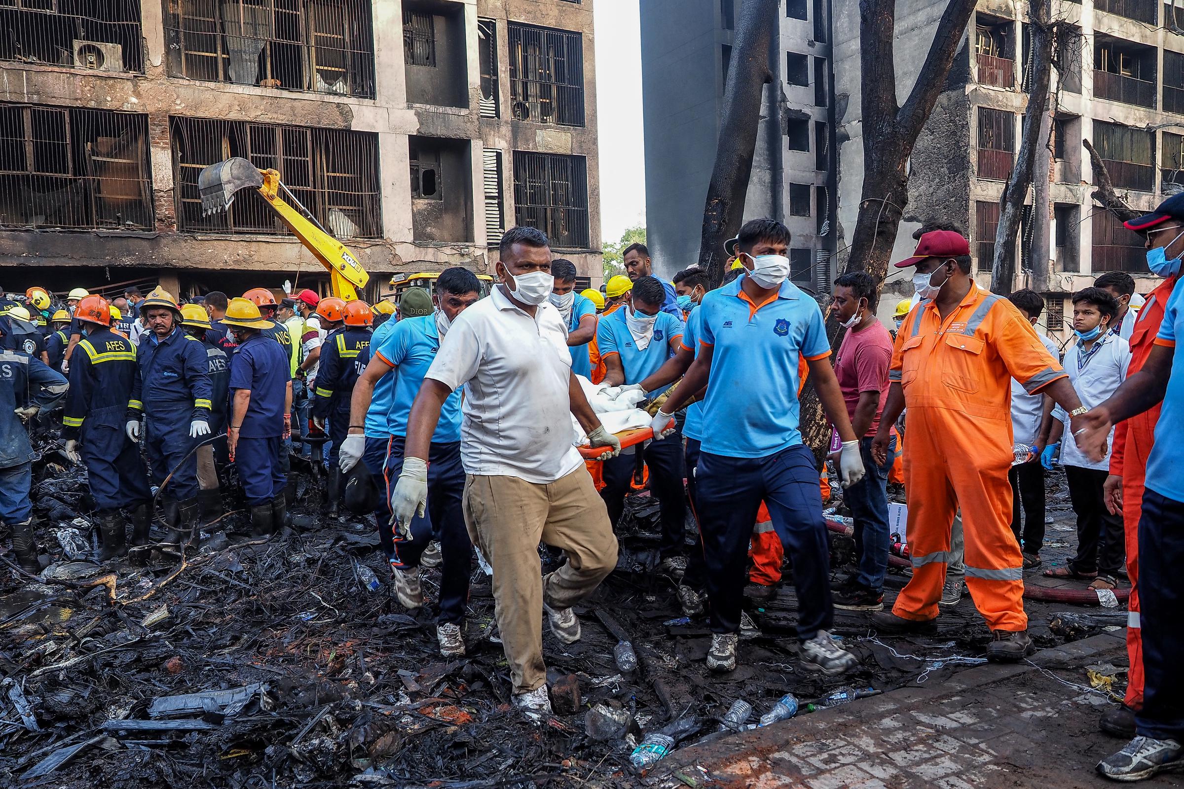 Rescue officials carry a victim's body at the site where Air India flight 171 crashed in a residential area near the airport in Ahmedabad on June 12, 2025. | Source: Getty Images