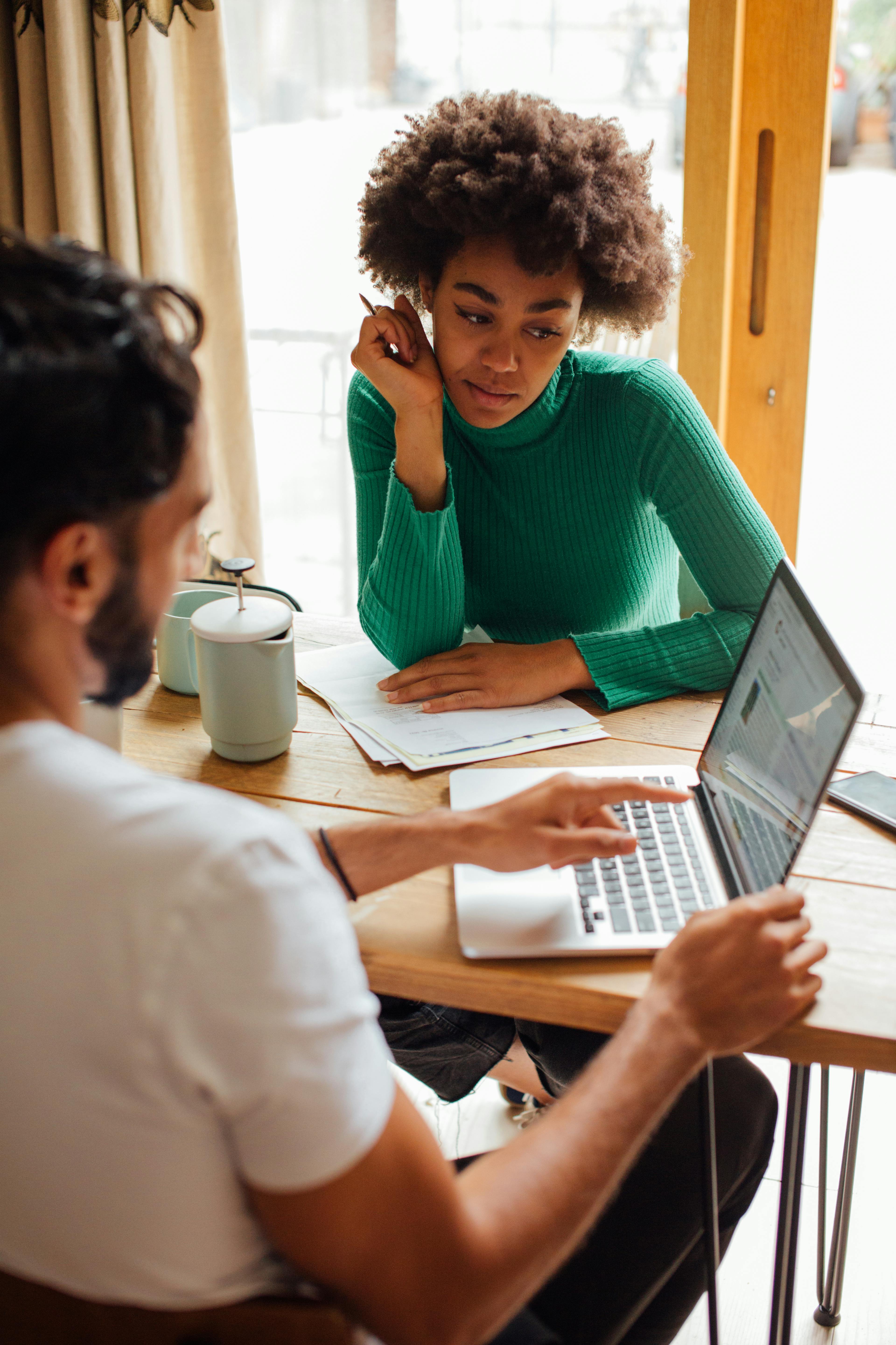 A man showing a woman his laptop screen | Source: Pexels
