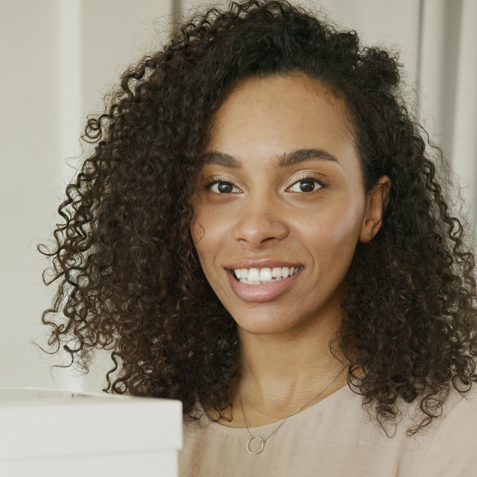 A woman in an office with a tight smile | Source: Pexels