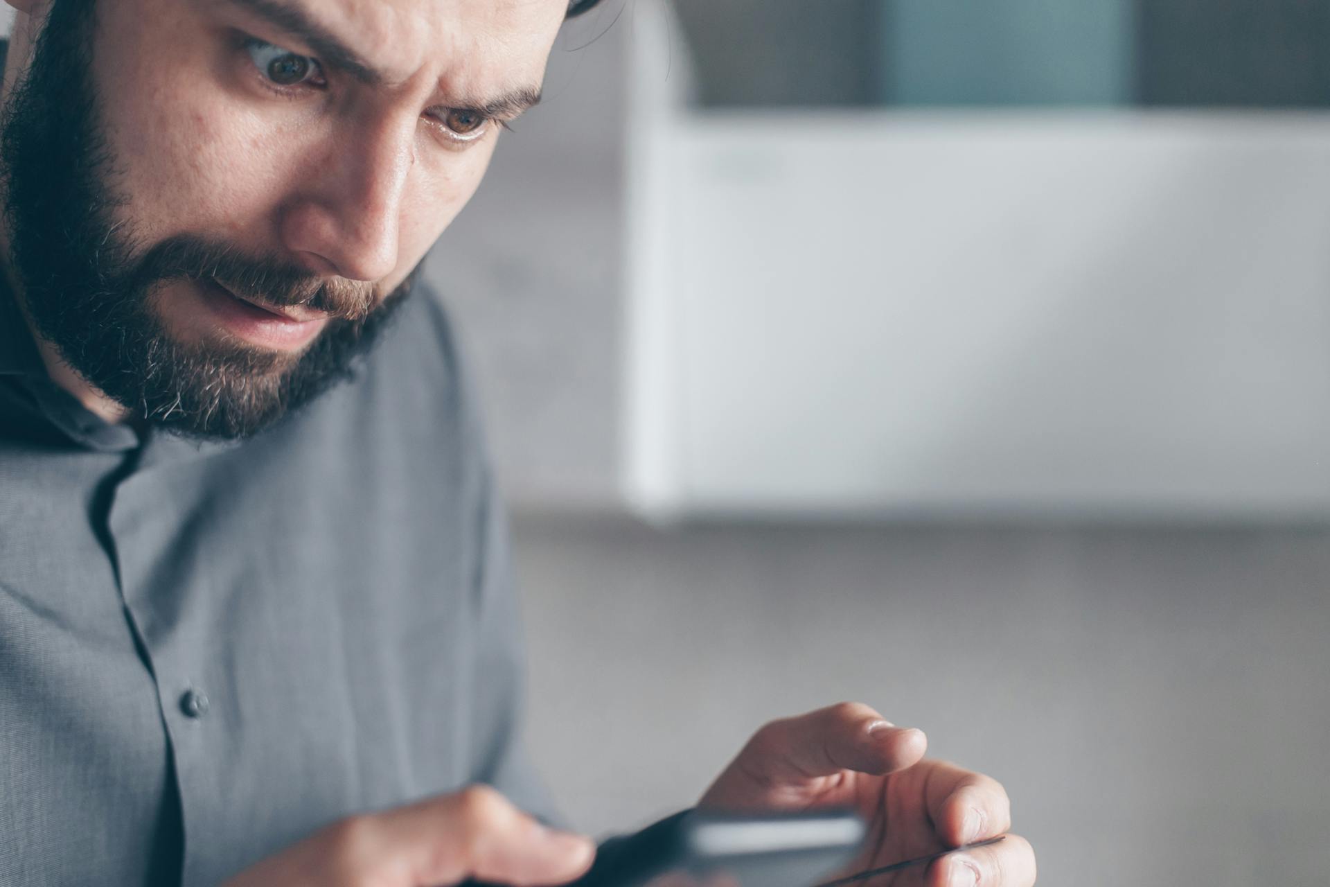 A man staring at his phone in shock | Source: Pexels