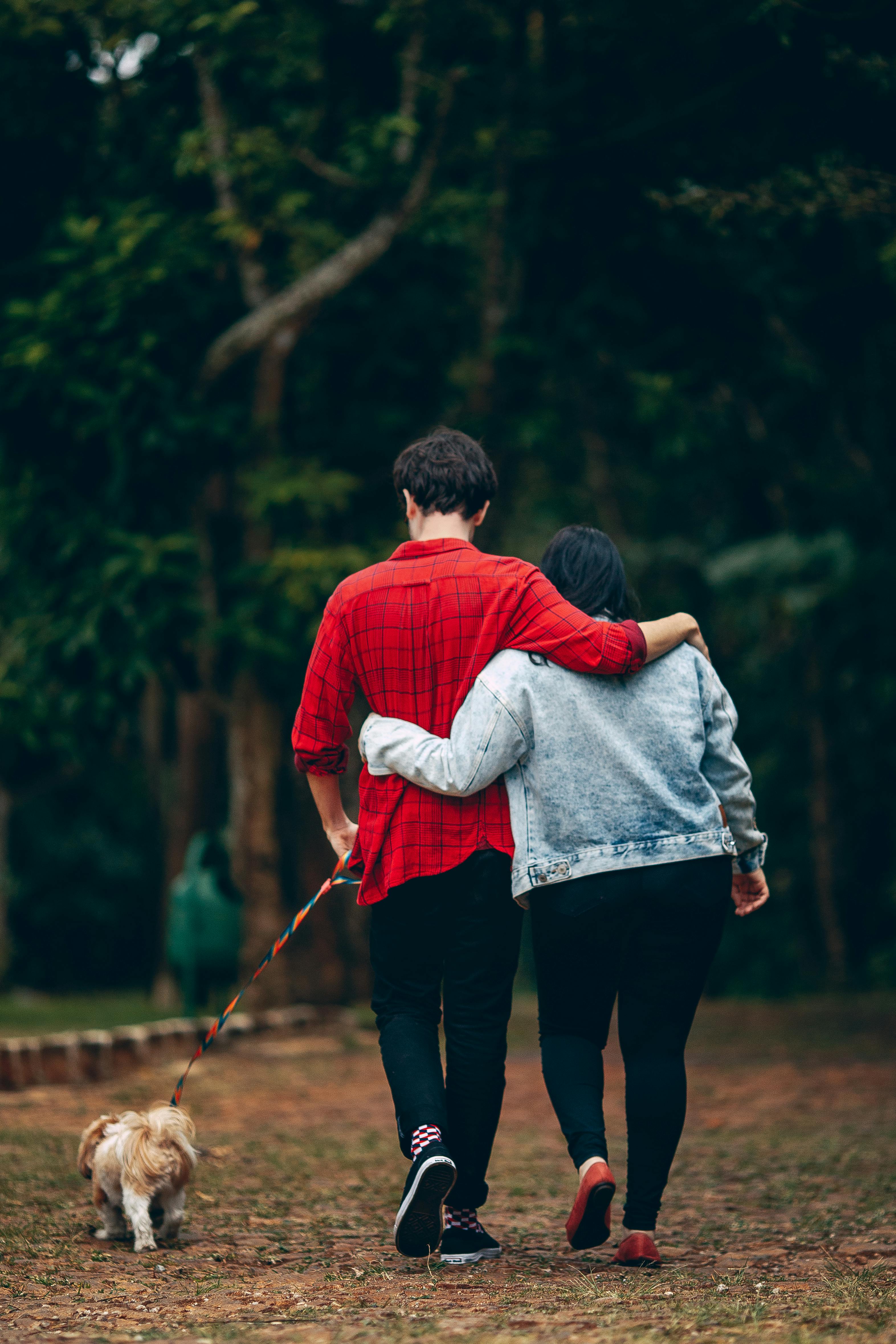 A couple walking a dog | Source: Pexels