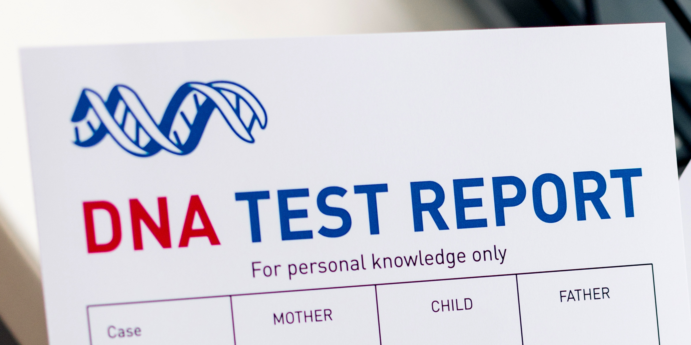 A DNA test report form showing sections for mother, child, and father | Source: Shutterstock