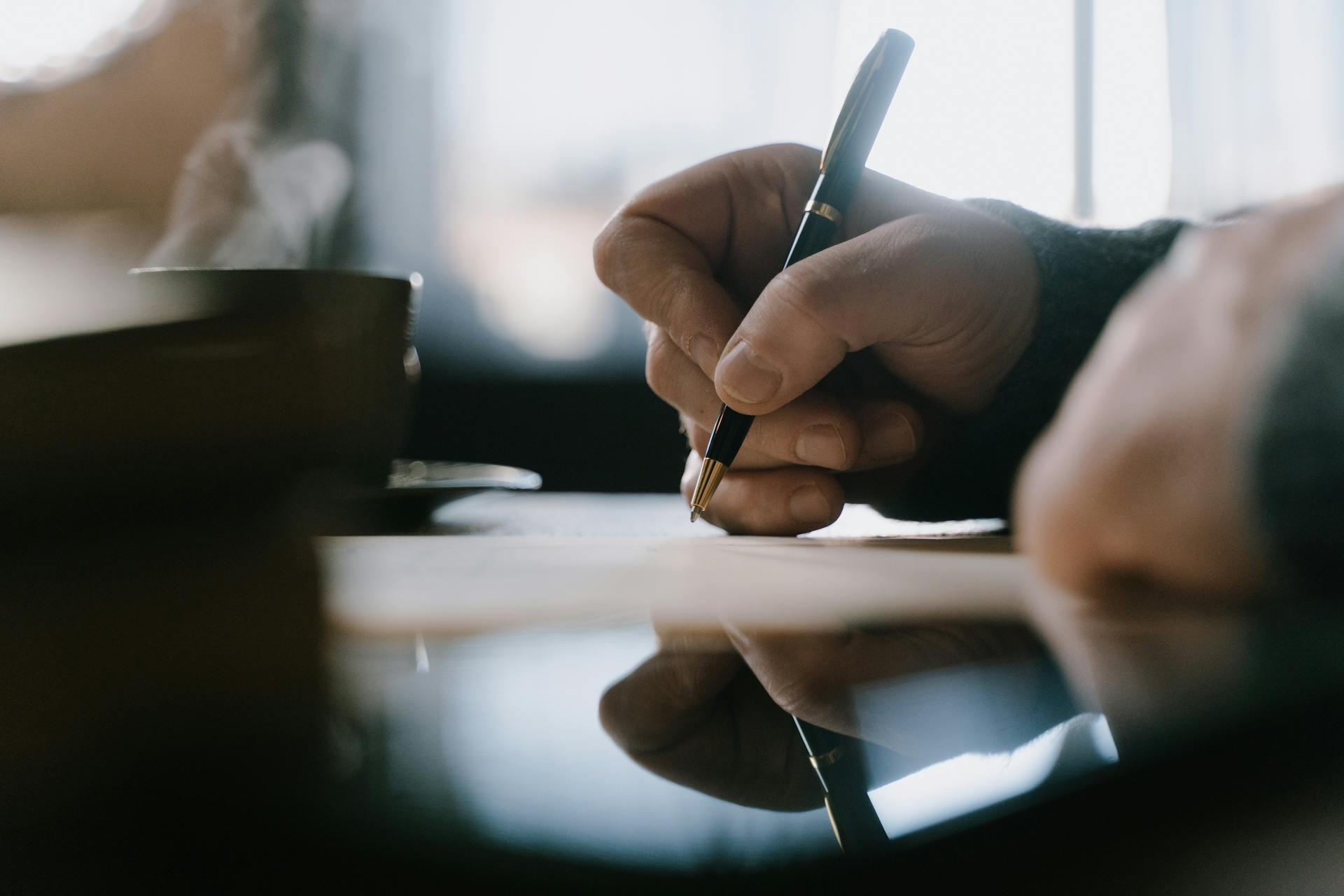 A man writing with a pen | Source: Pexels