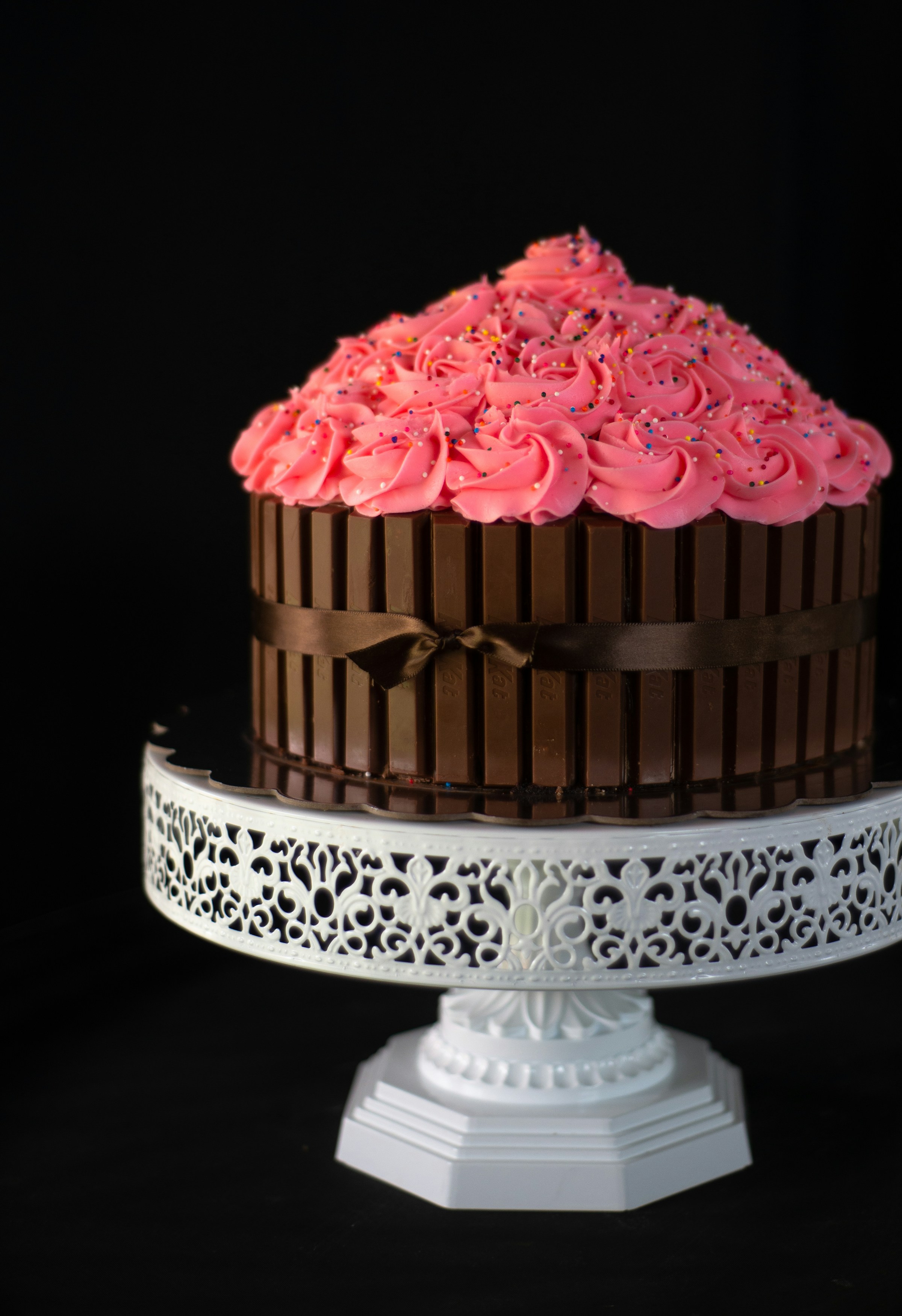 A chocolate cake with pink rosettes | Source: Unsplash