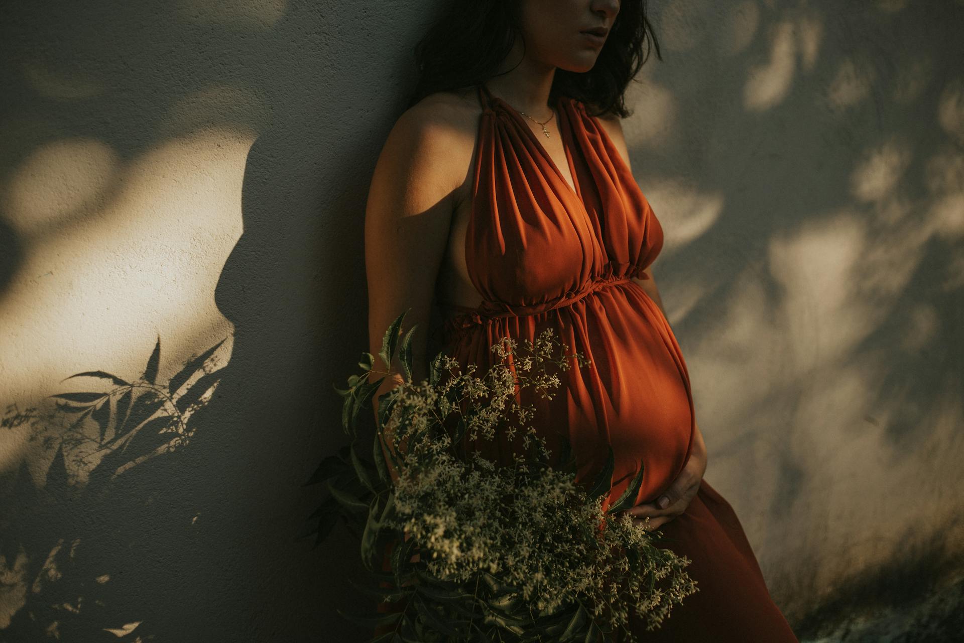 A pregnant woman standing by the wall | Source: Pexels