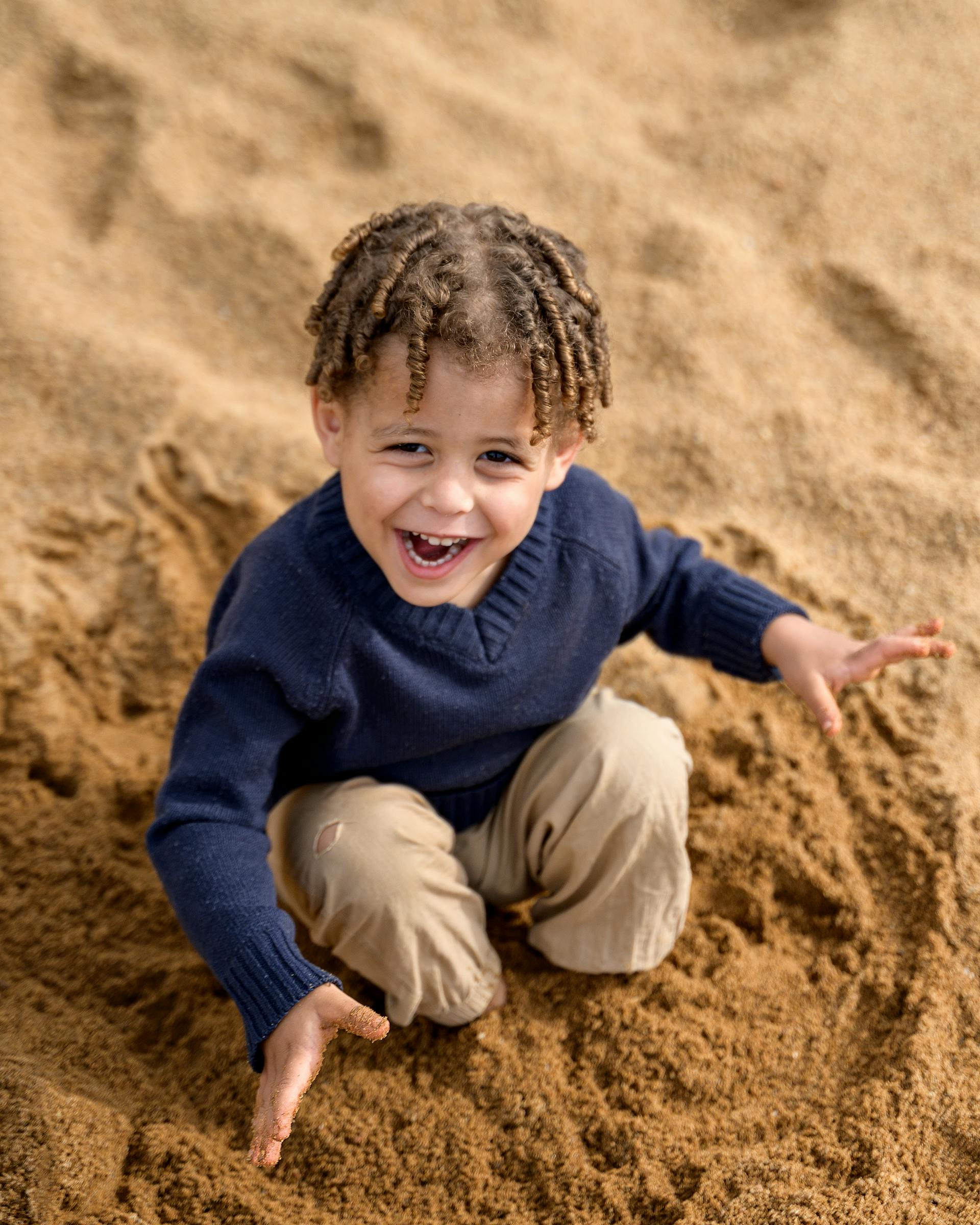 A toddler boy playing in sand | Source: Pexels