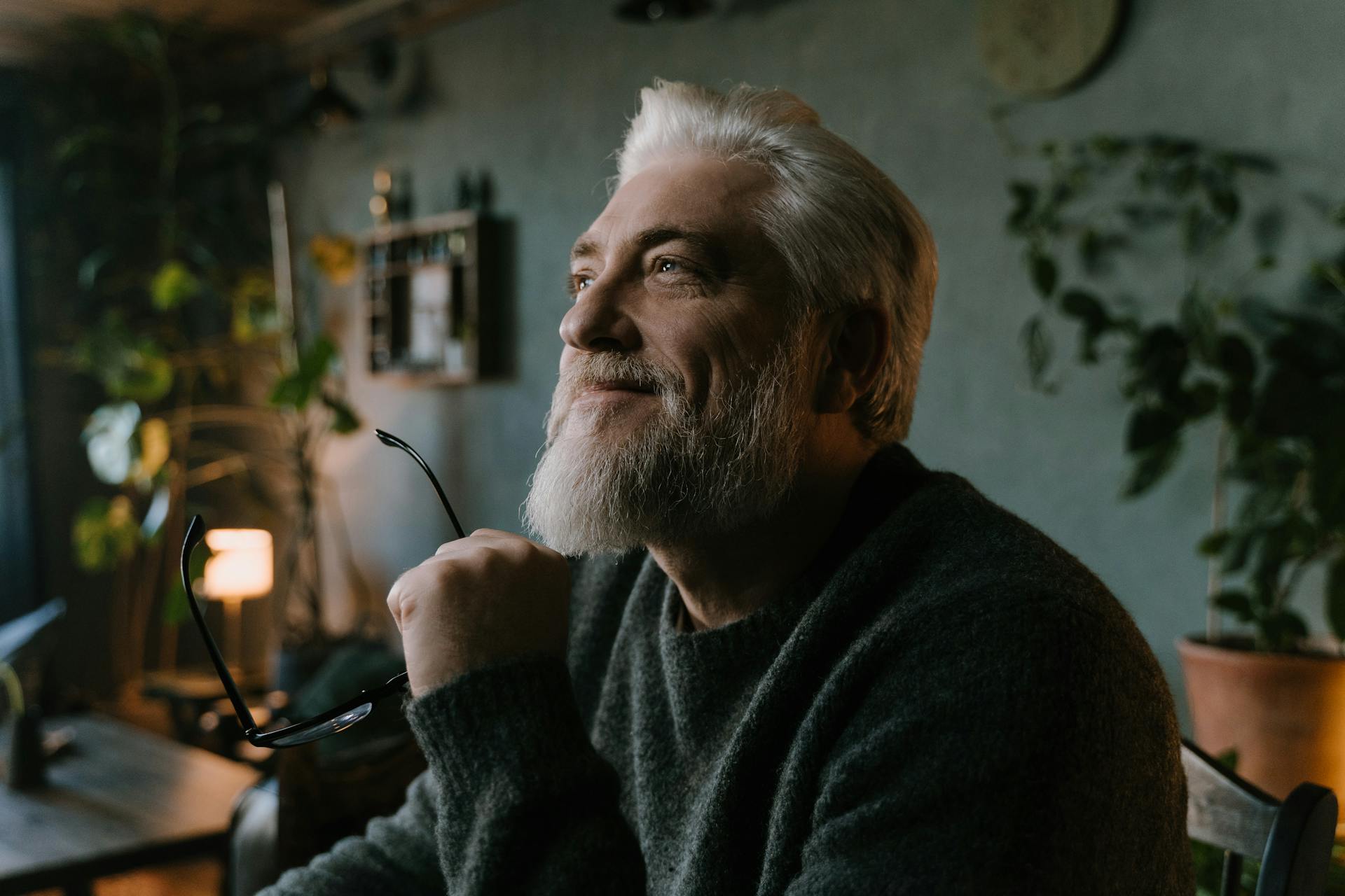 A senior man smiling while holding his eyeglasses | Source: Pexels
