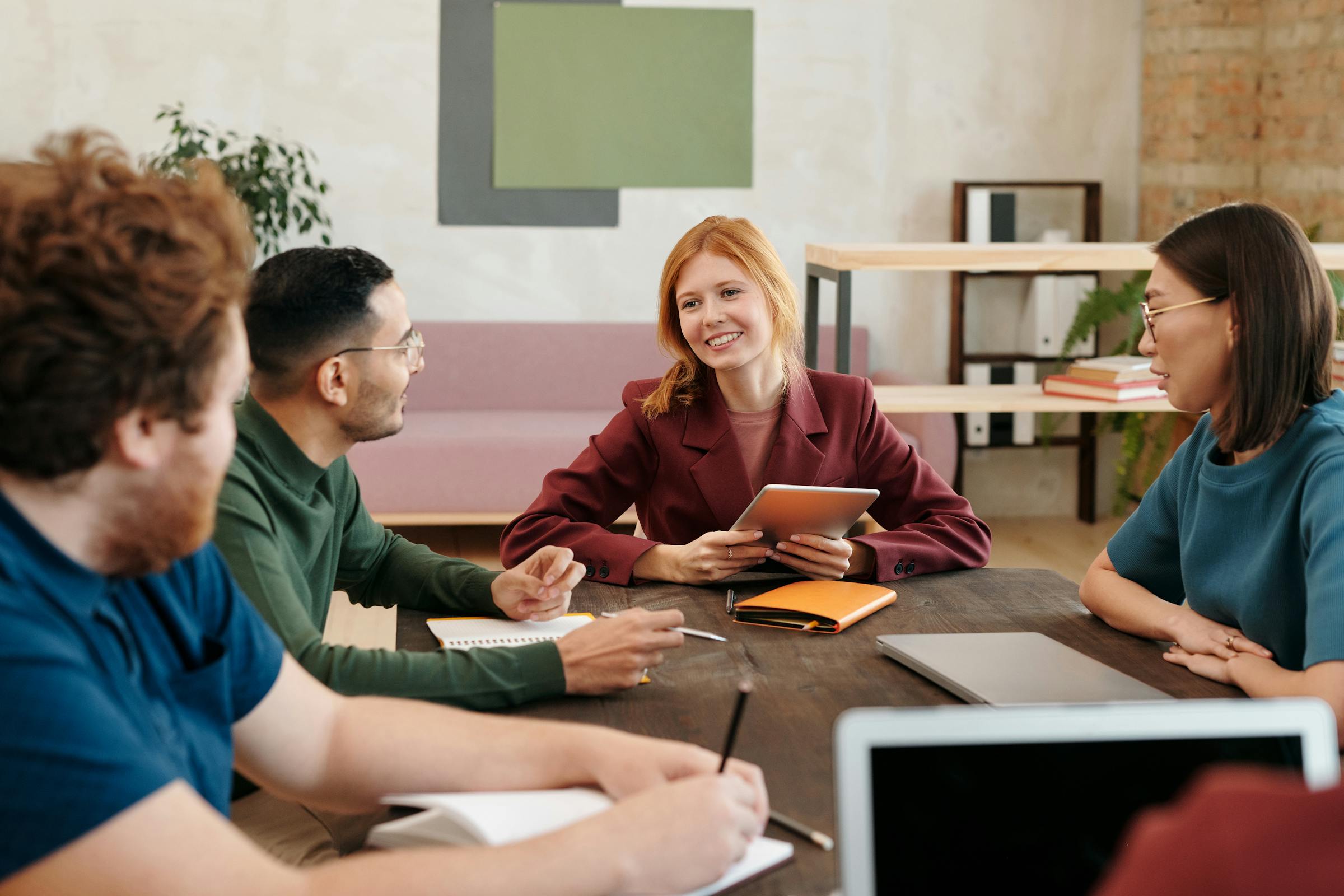 Coworkers smiling while talking in a conference room | Source: Pexels