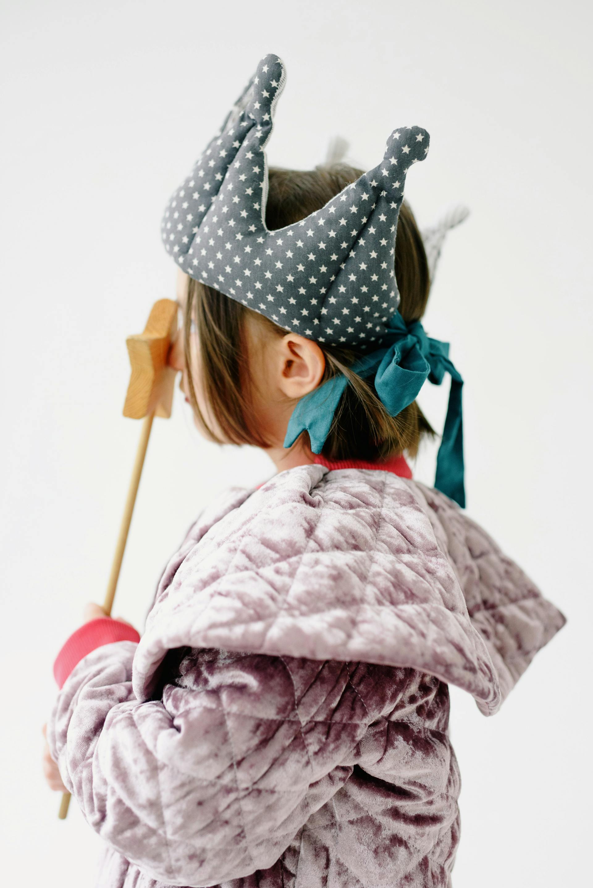 A little girl wearing a crown and holding a wand | Source: Pexels