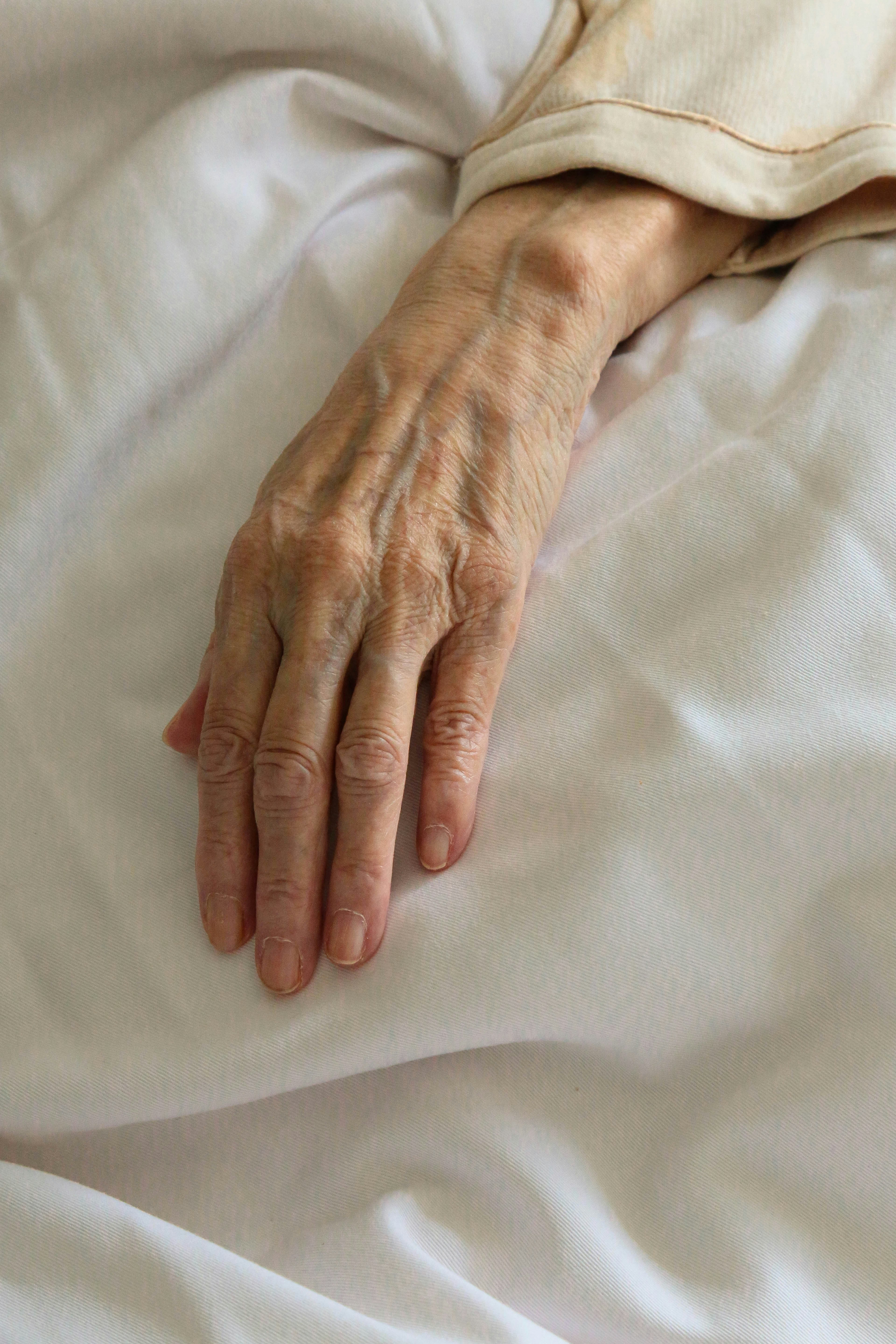 A sick woman's hand on a bed | Source: Unsplash
