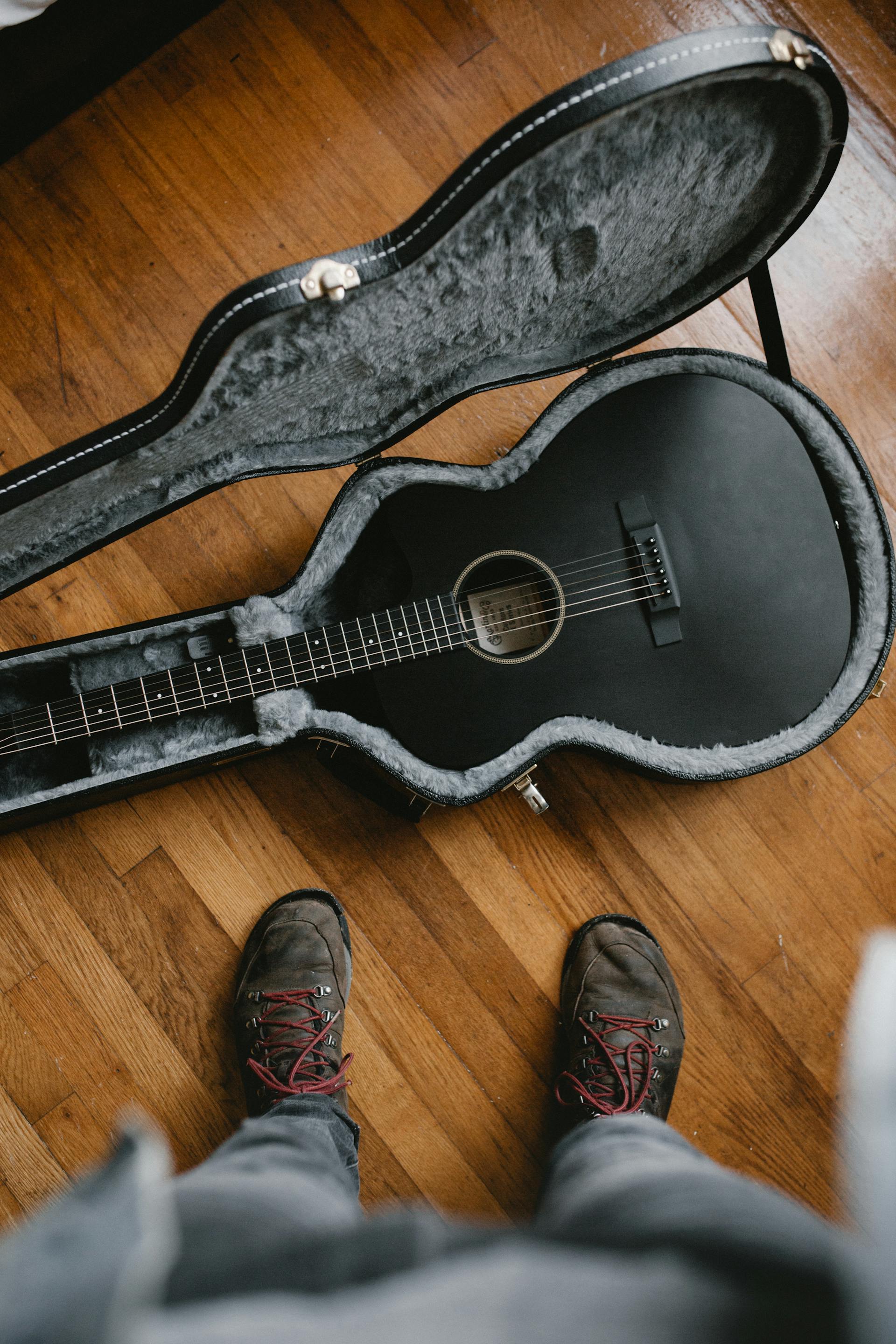 A man standing near a guitar | Source: Pexels