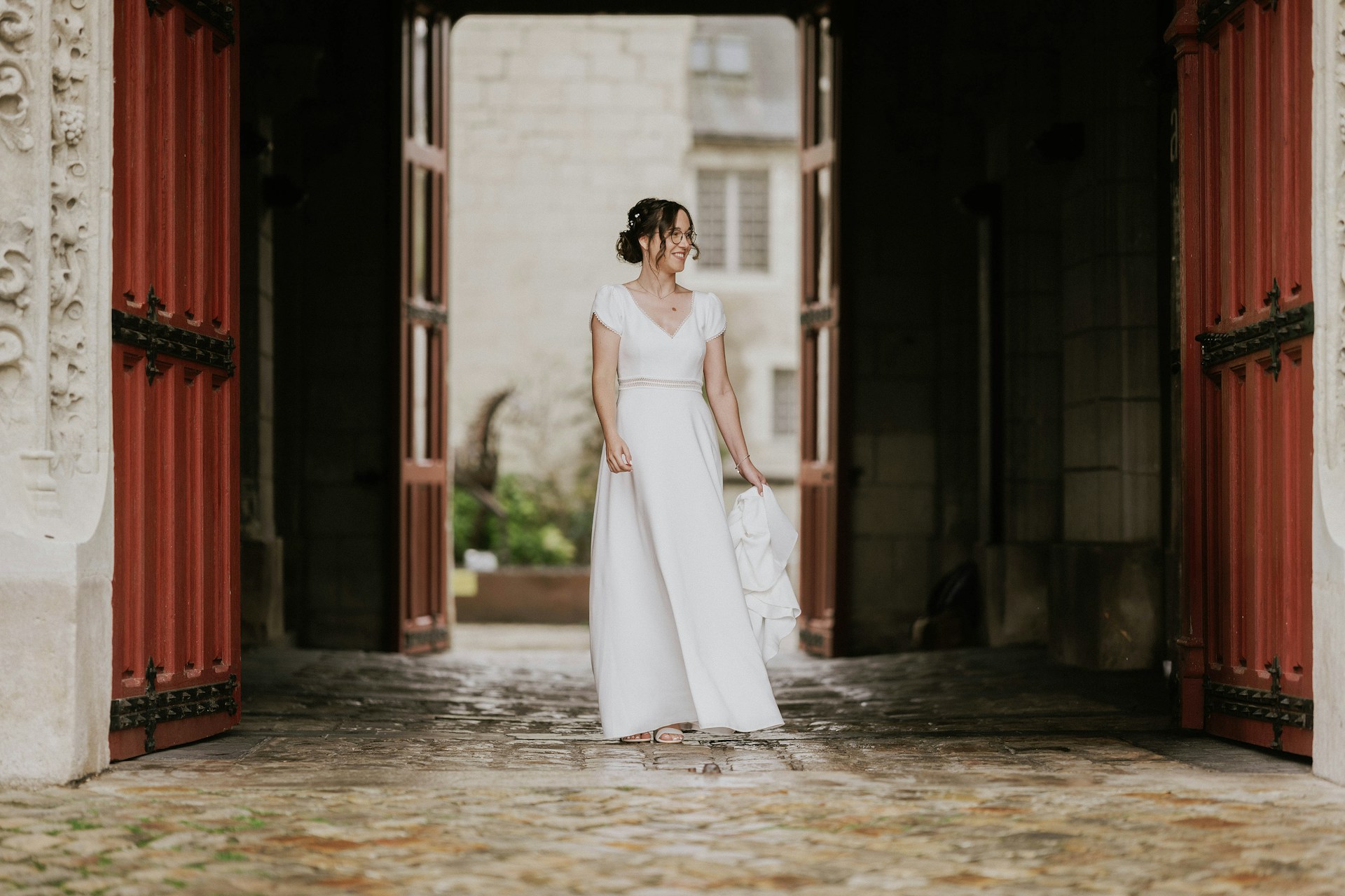 A bride standing near a doorway smiling at someone | Source: Unsplash