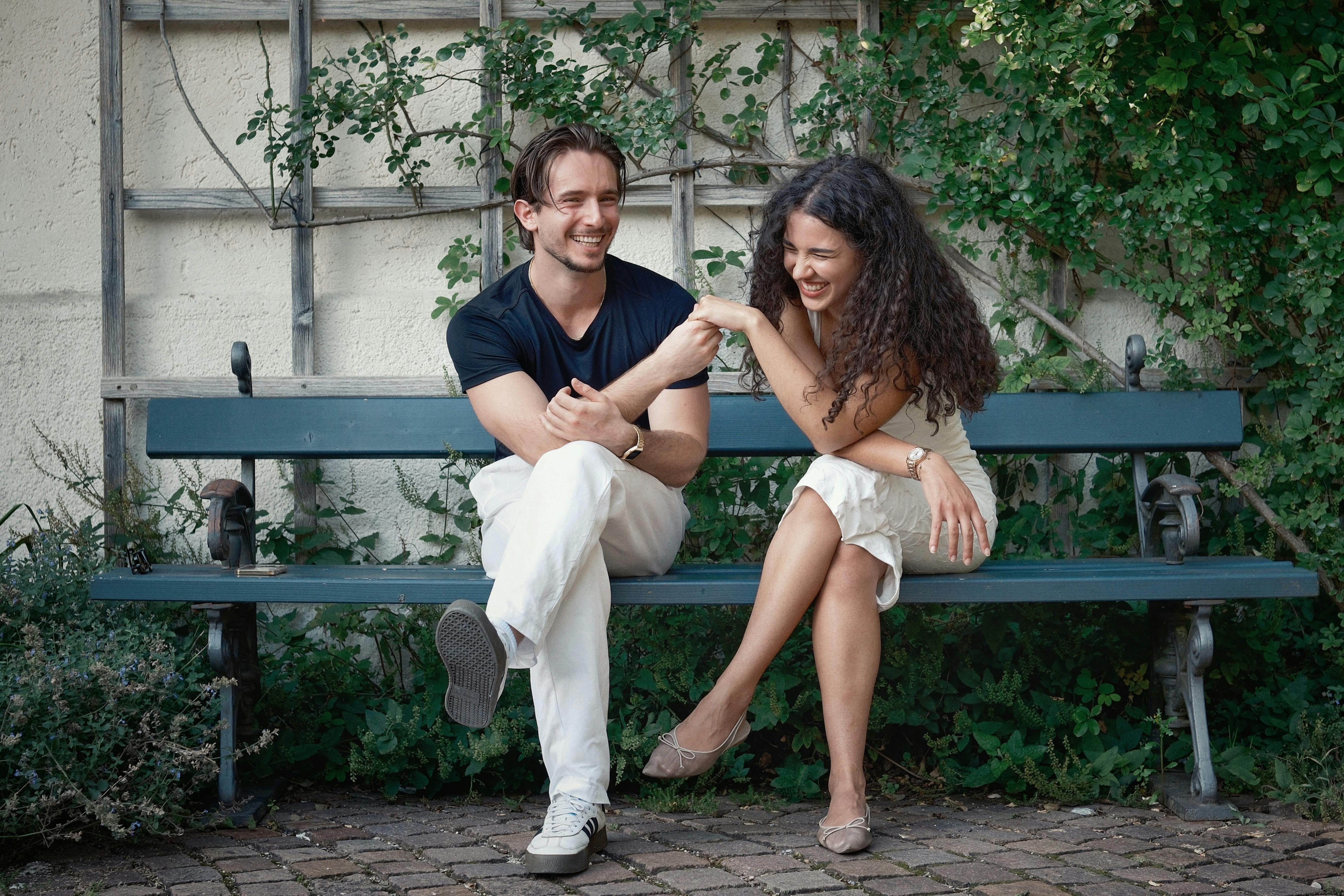 Couple laughing on a park bench | Source: Pexels