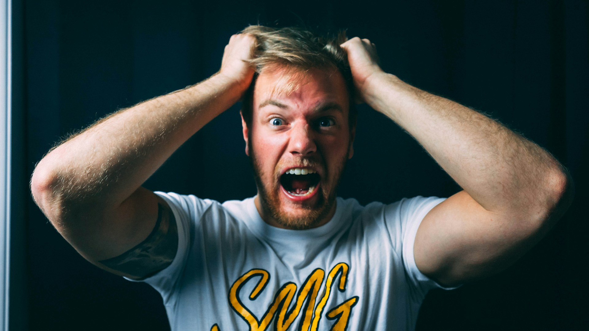 An man tugging his hair in frustration | Source: Unsplash