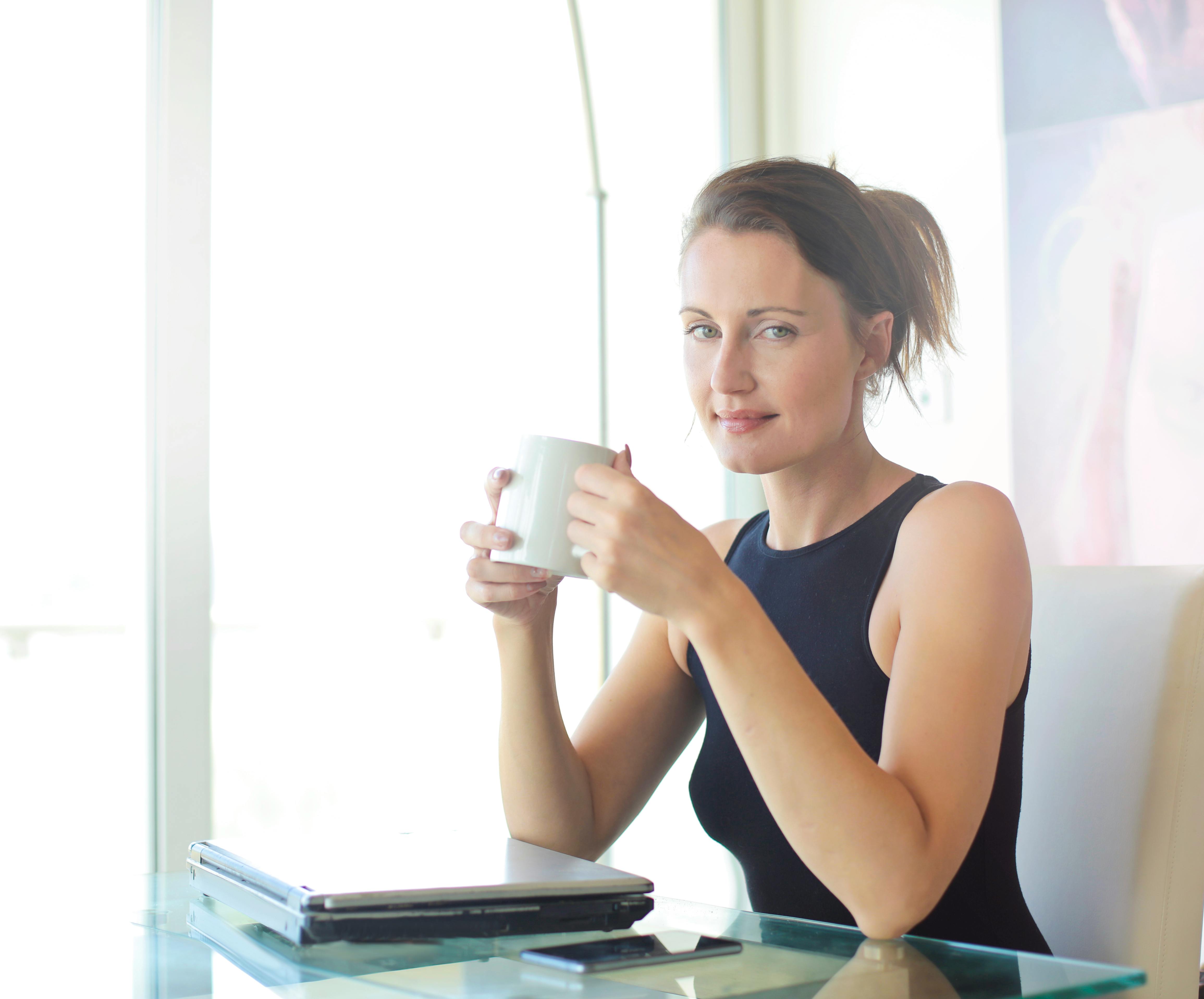 A woman sitting at a table with a cup of tea | Source: Pexels