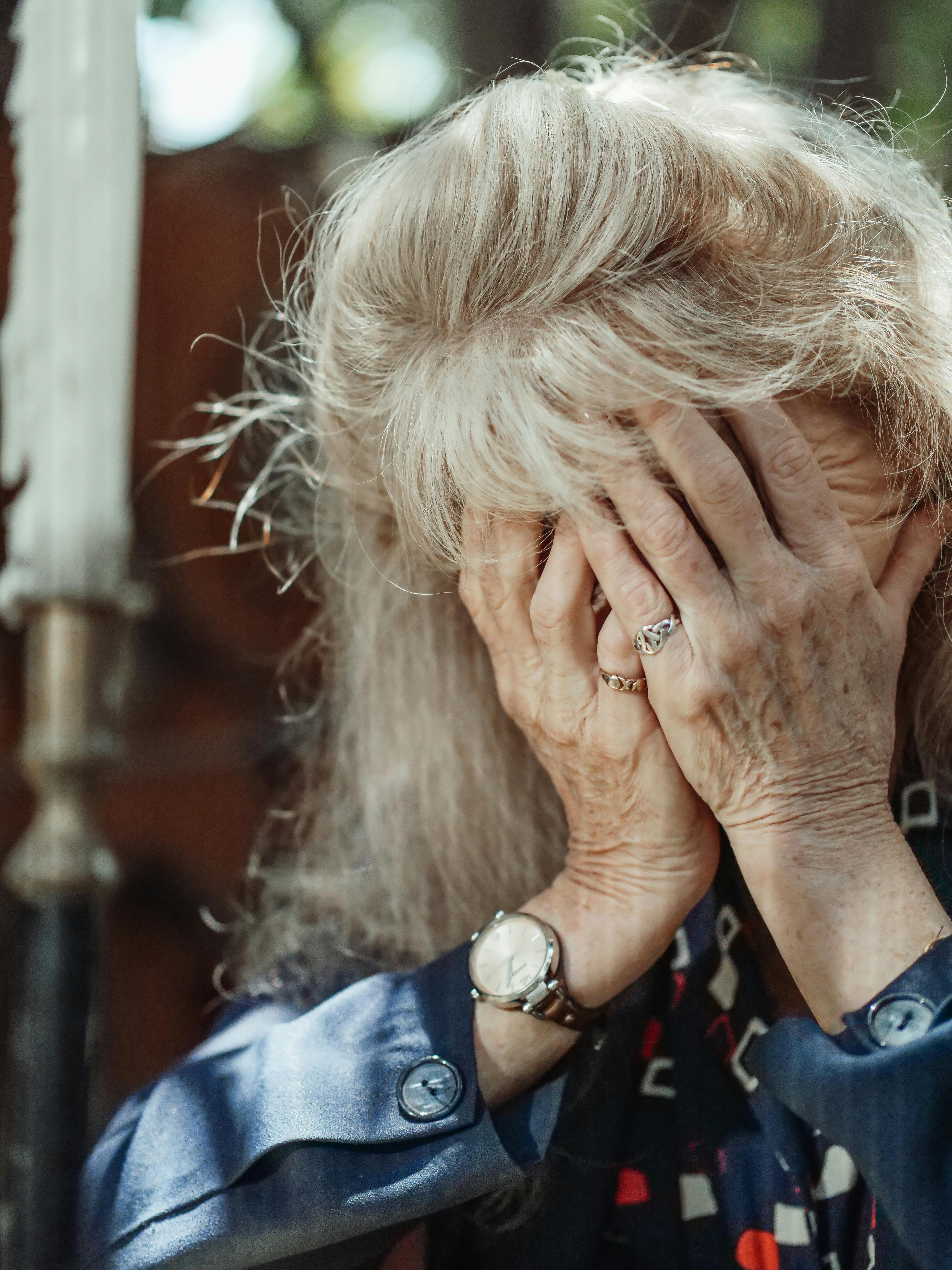 An old woman holding her head | Source: Pexels