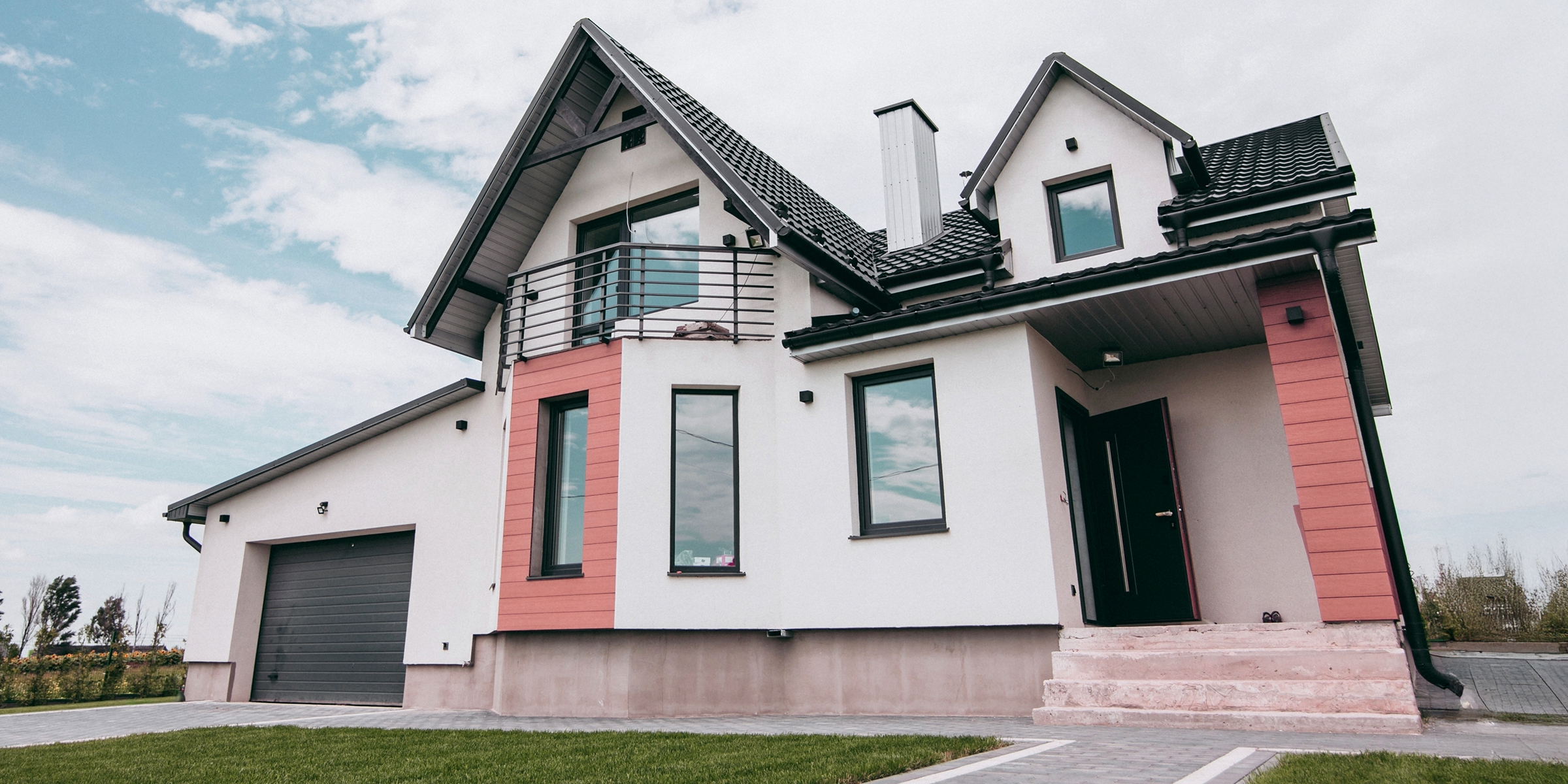Modern suburban house set against a partly cloudy sky | Source: Shutterstock