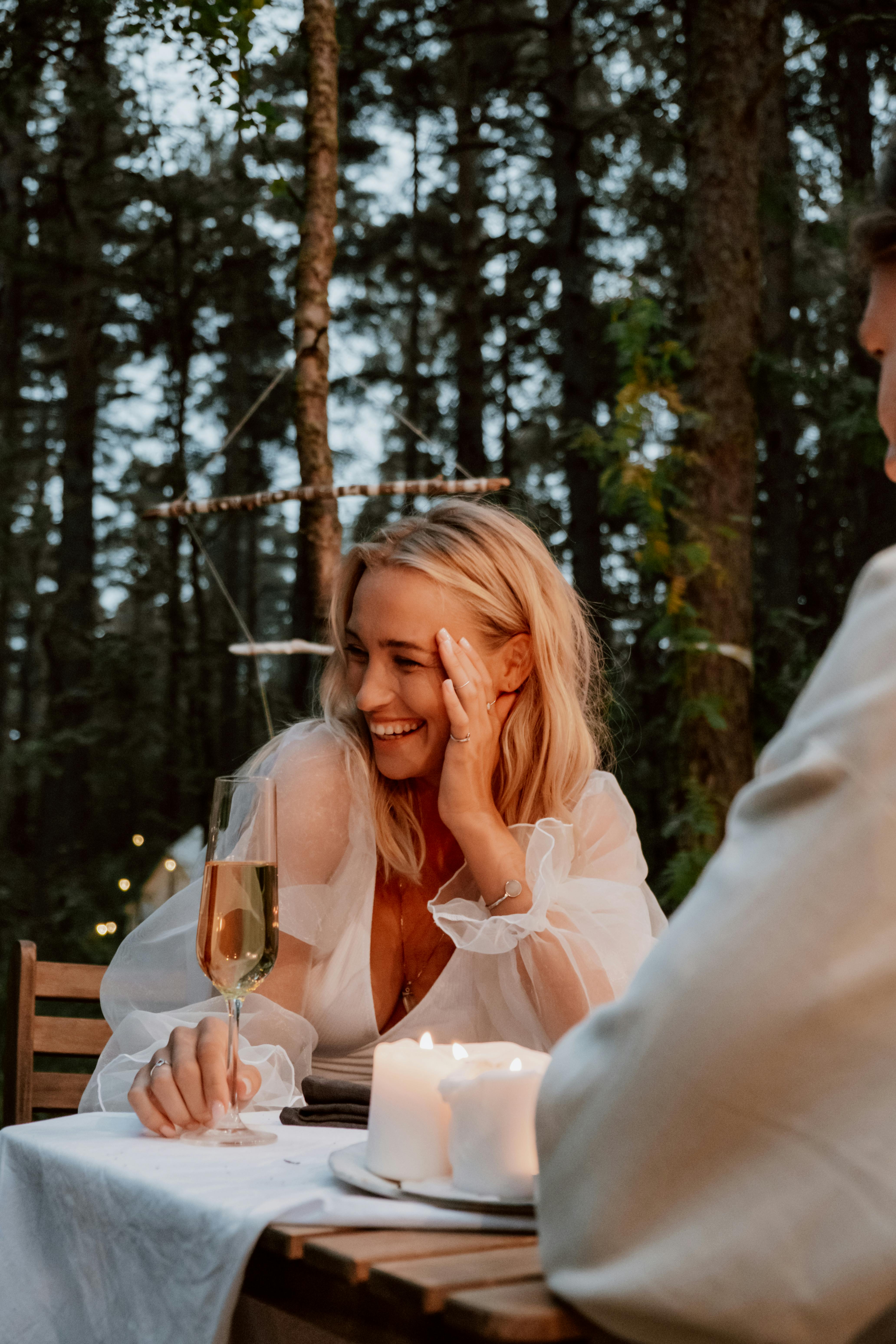 A woman laughing during a dinner date | Source: Pexels