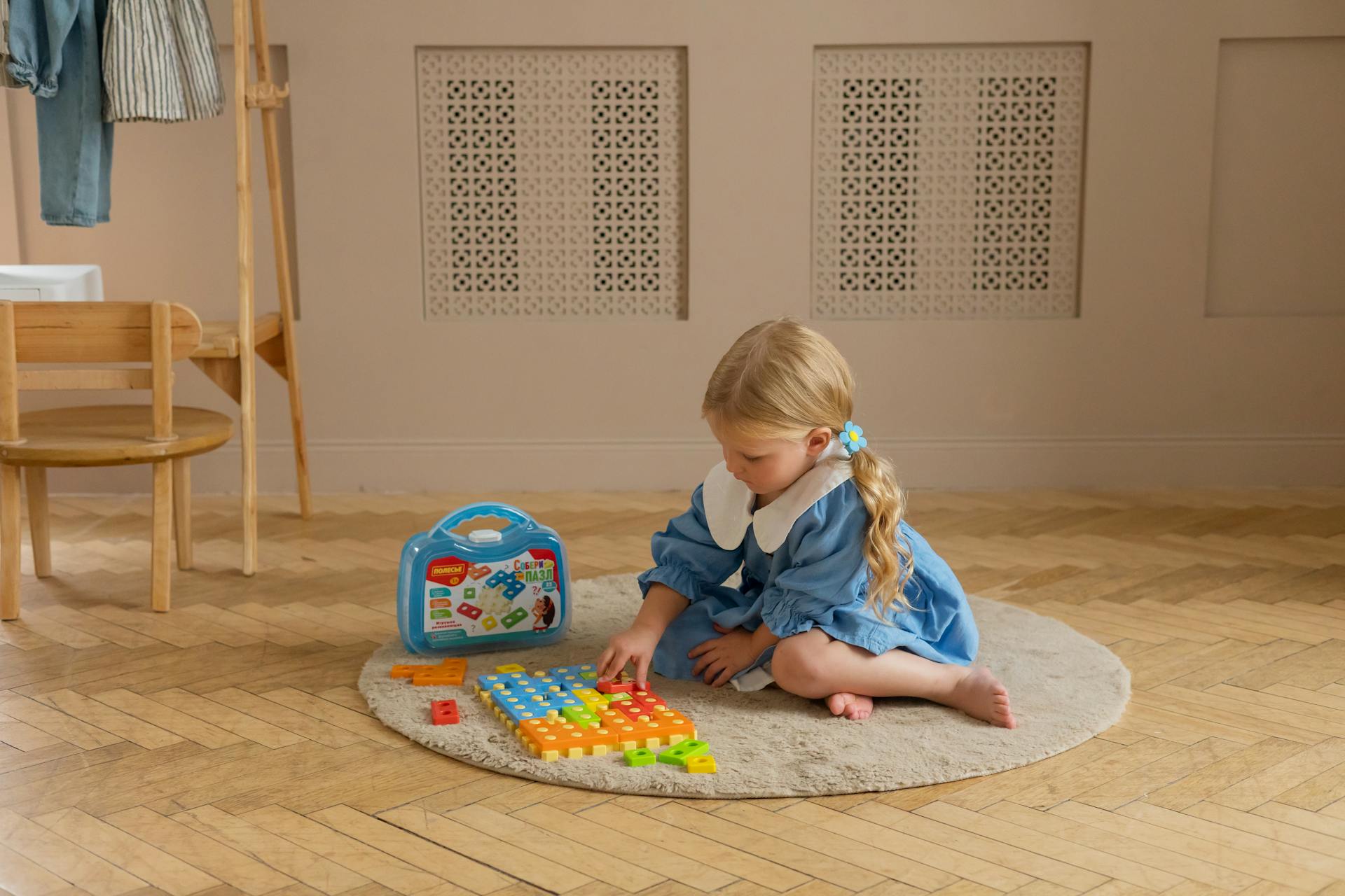 A little girl sitting on the floor and playing with colorful blocks | Source: Pexels