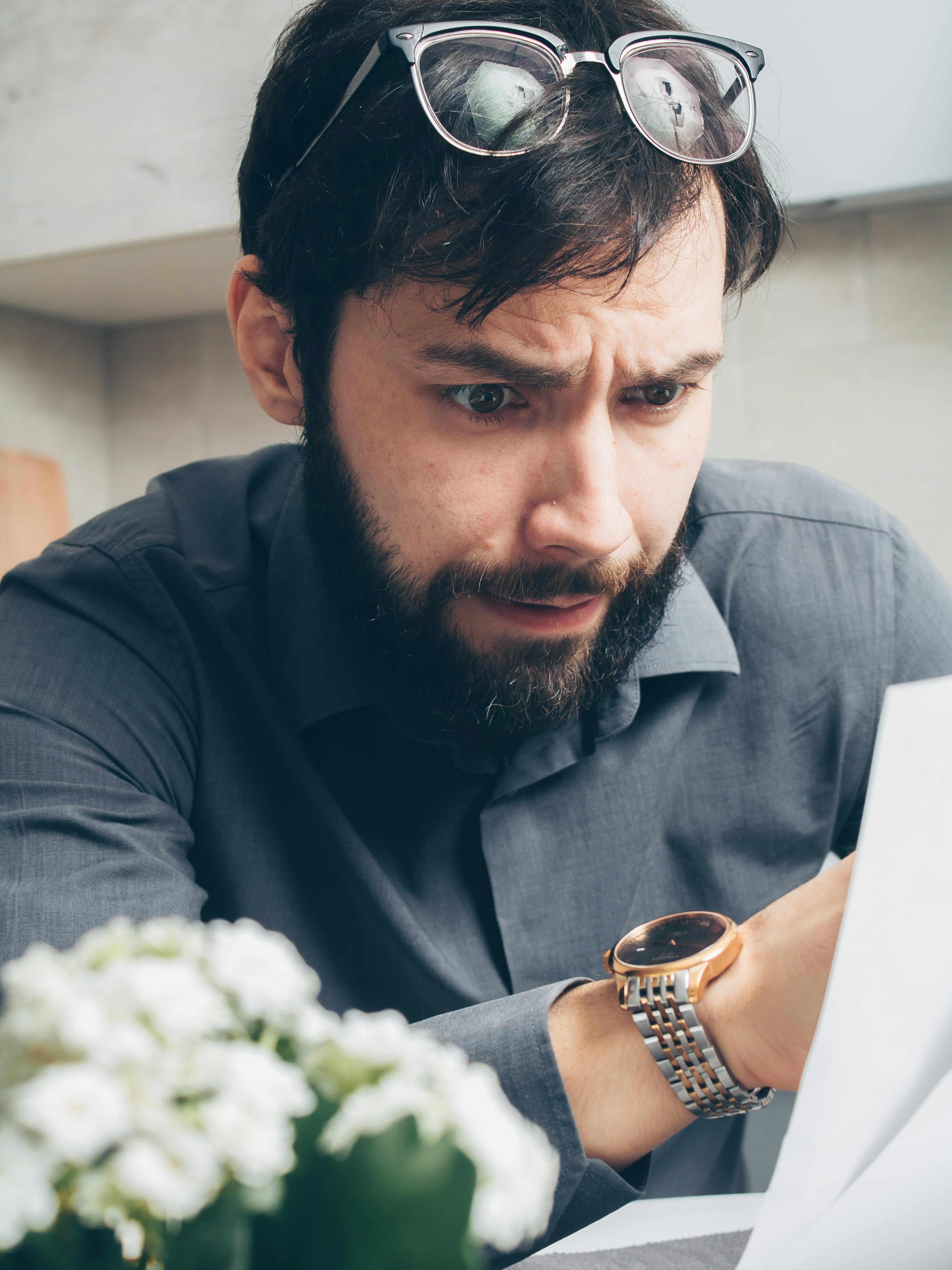 An unhappy man reading a note | Source: Pexels