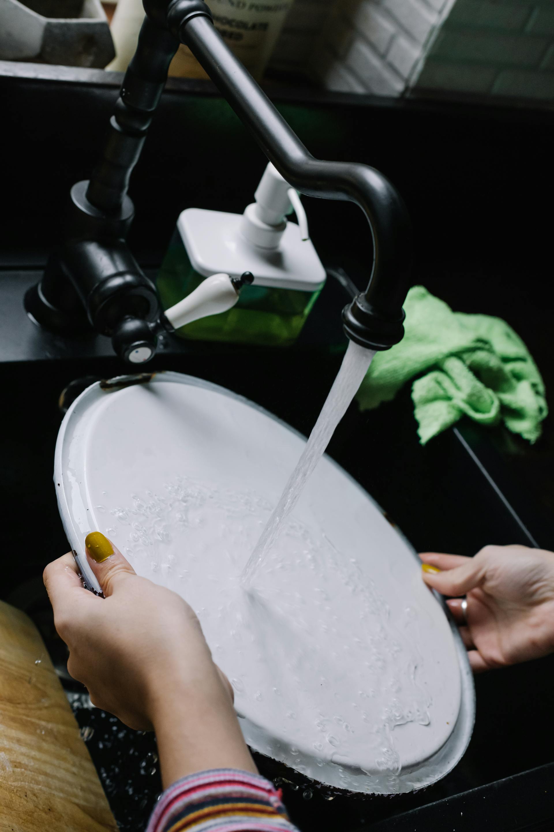 A woman washing a plate | Source: Pexels