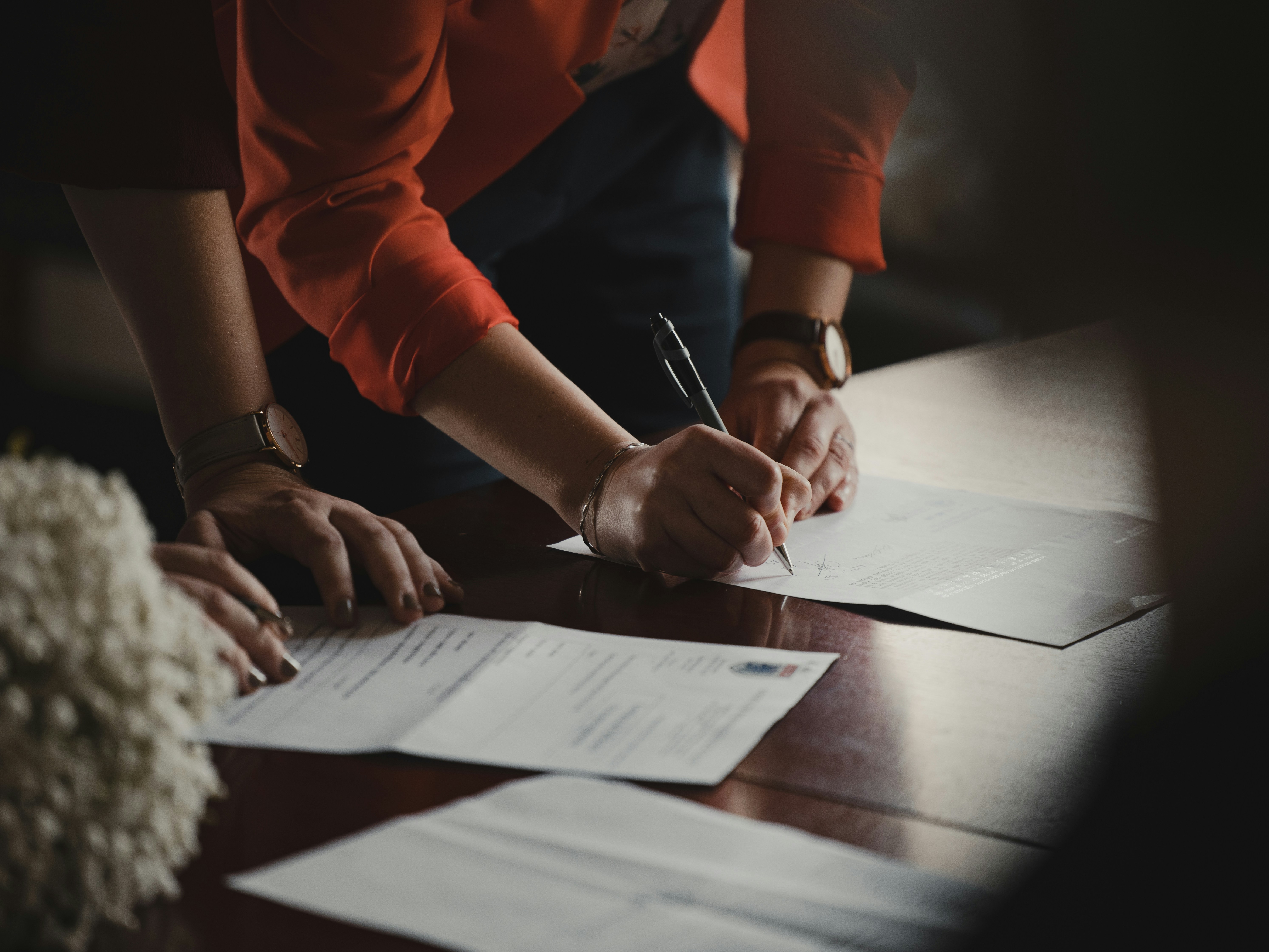 People signing documents on the table | Source: Unsplash