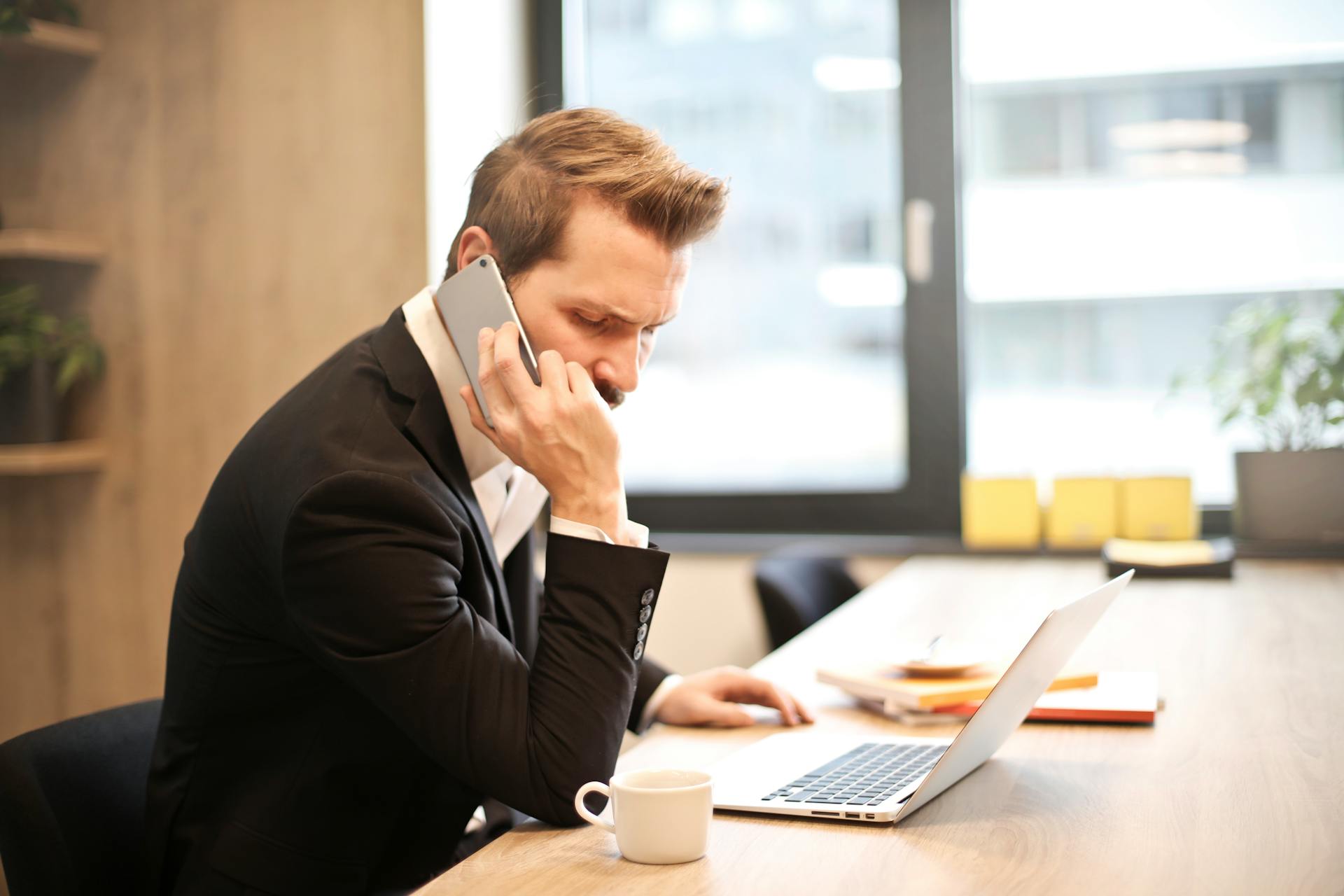 Man taking a phone call in his office | Source: Pexels