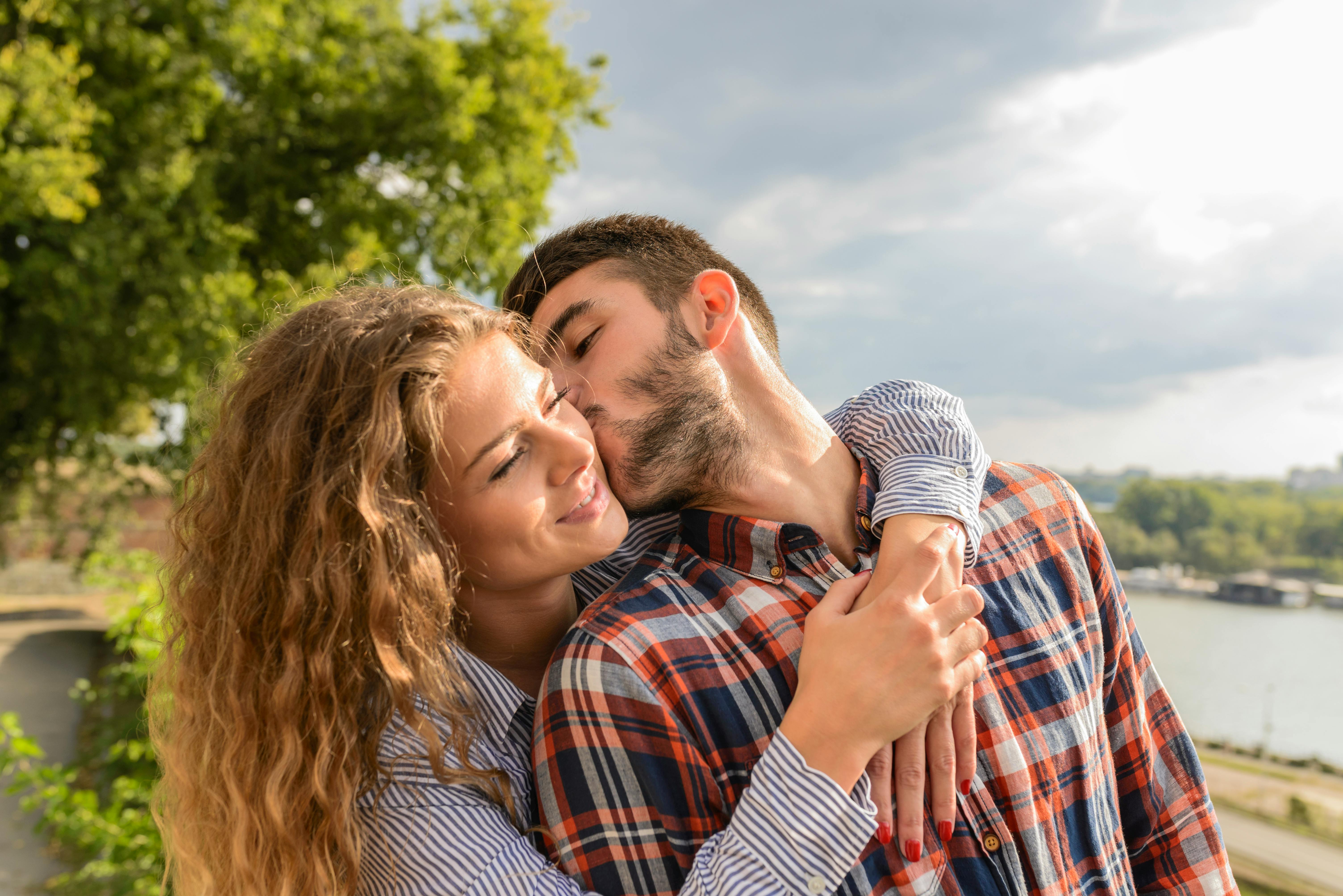 A man planting a kiss on a woman's cheek | Source: Pexels