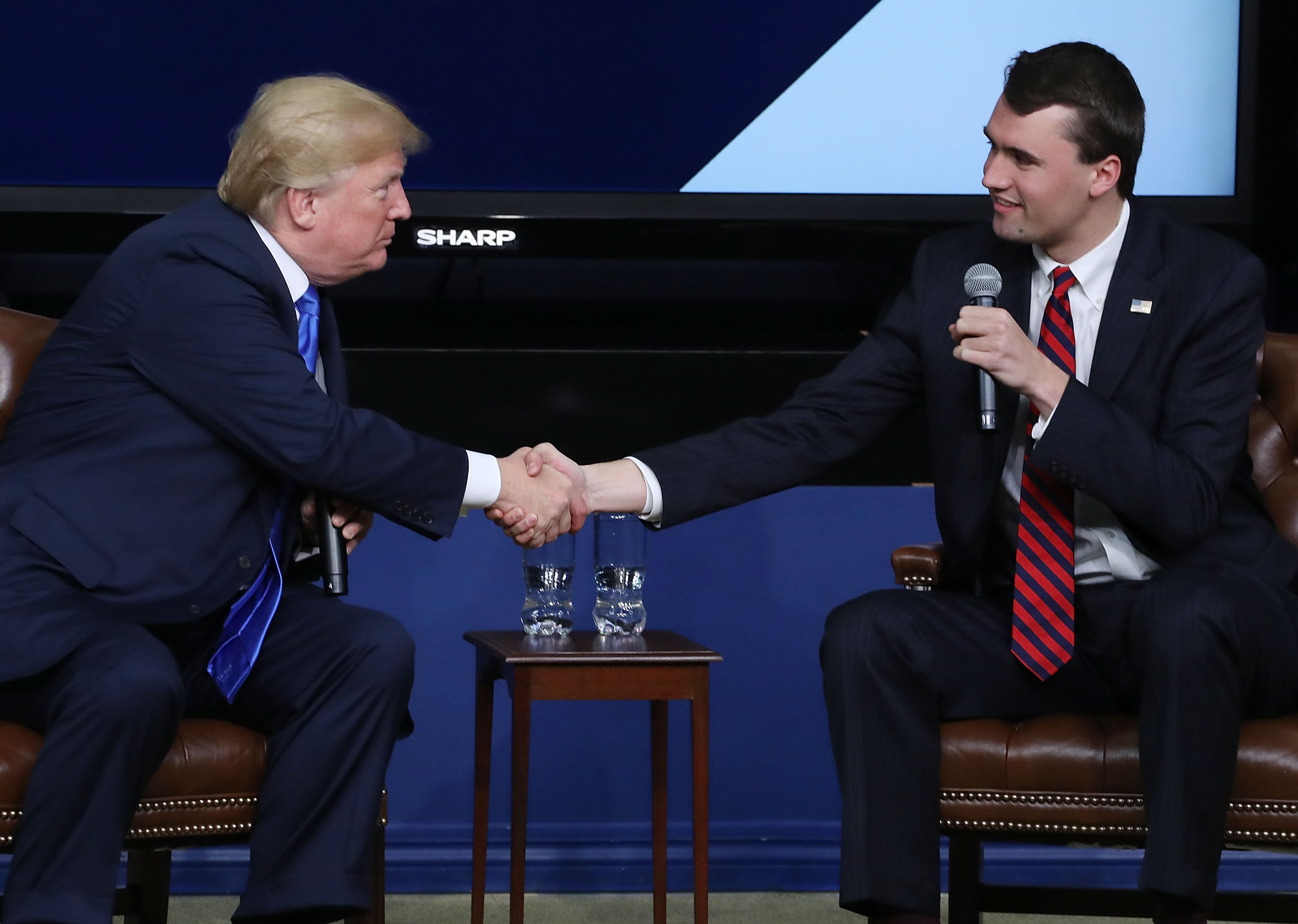 Donald Trump shakes hands with conservative activist Charlie Kirk at a forum dubbed the Generation Next Summit at the White House on March 22, 2018 in Washington, D.C. | Source: Getty Images