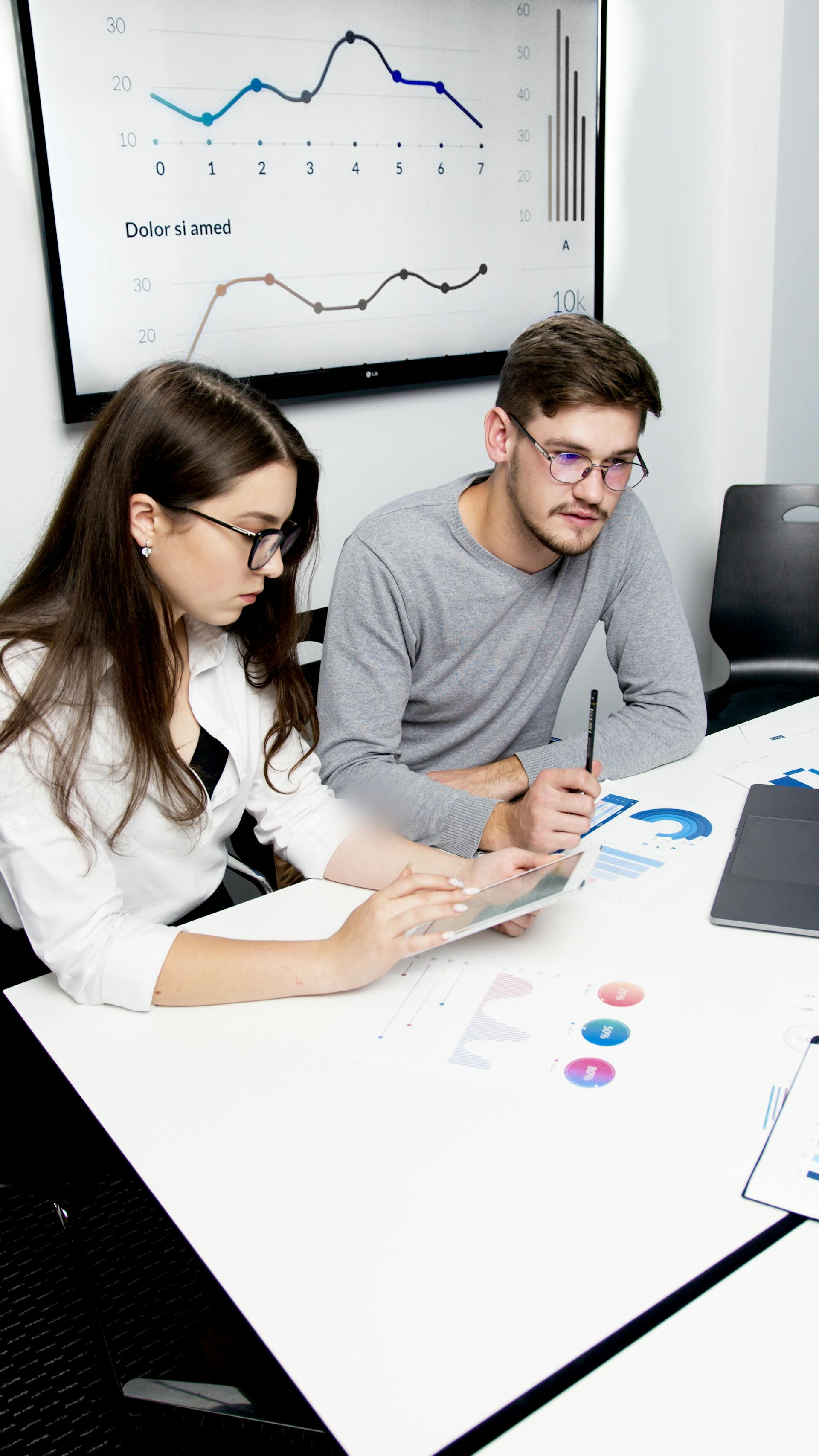 A man and woman working together in a conference room in an office | Source: Pexels