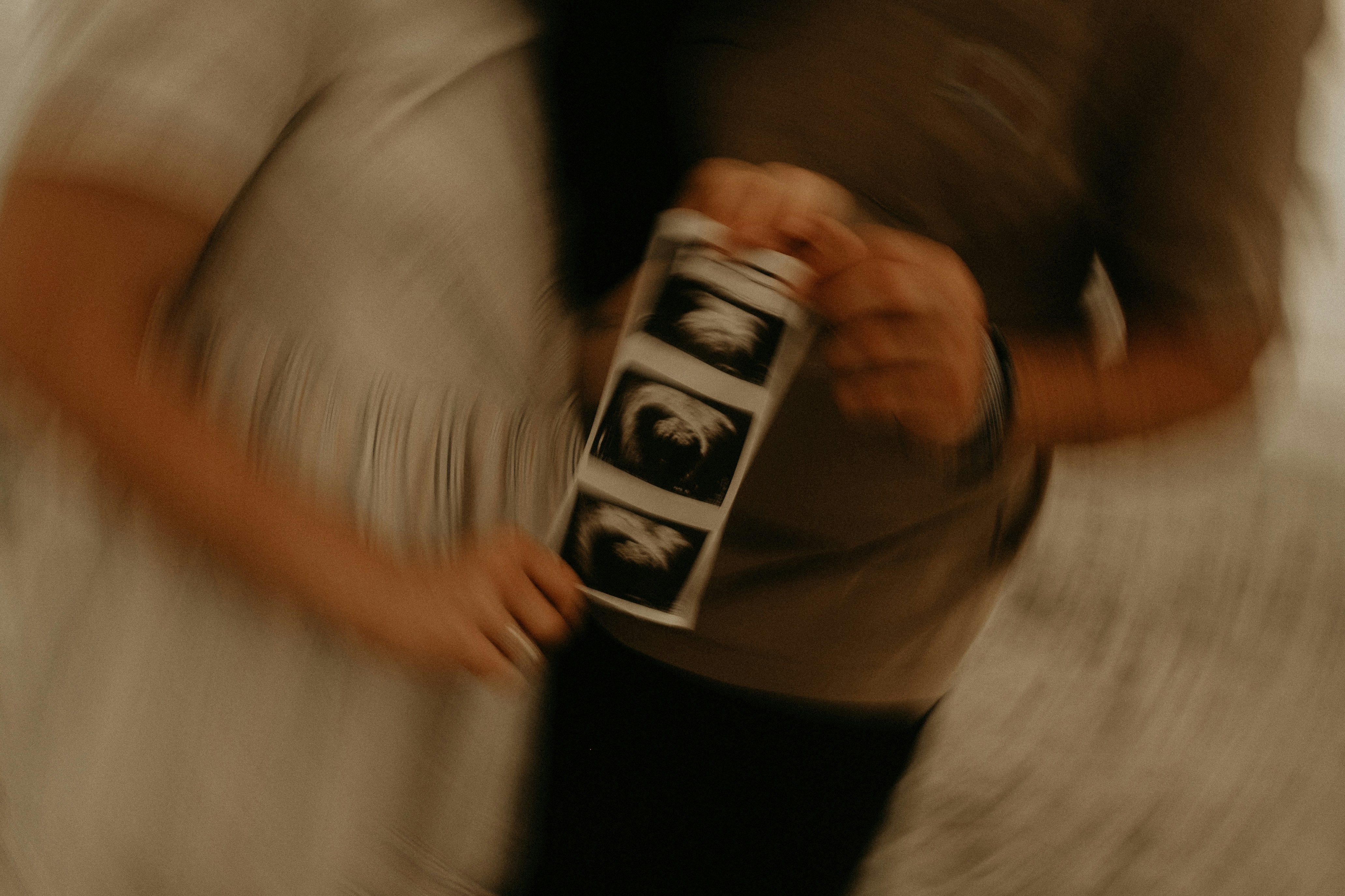 A couple holding ultrasound images | Source: Unsplash