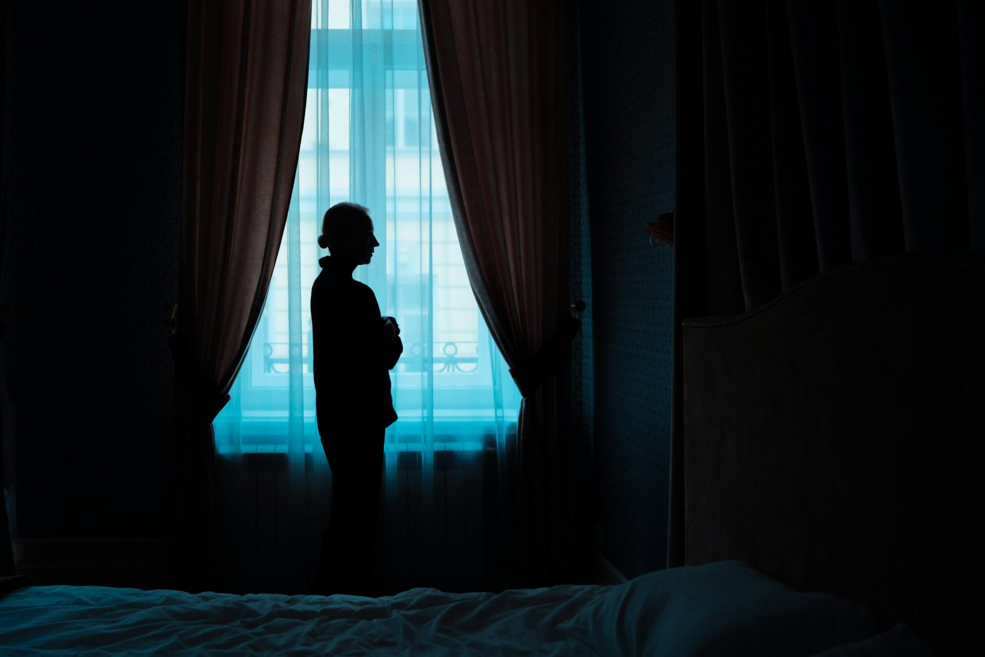A woman standing near a window | Source: Pexels