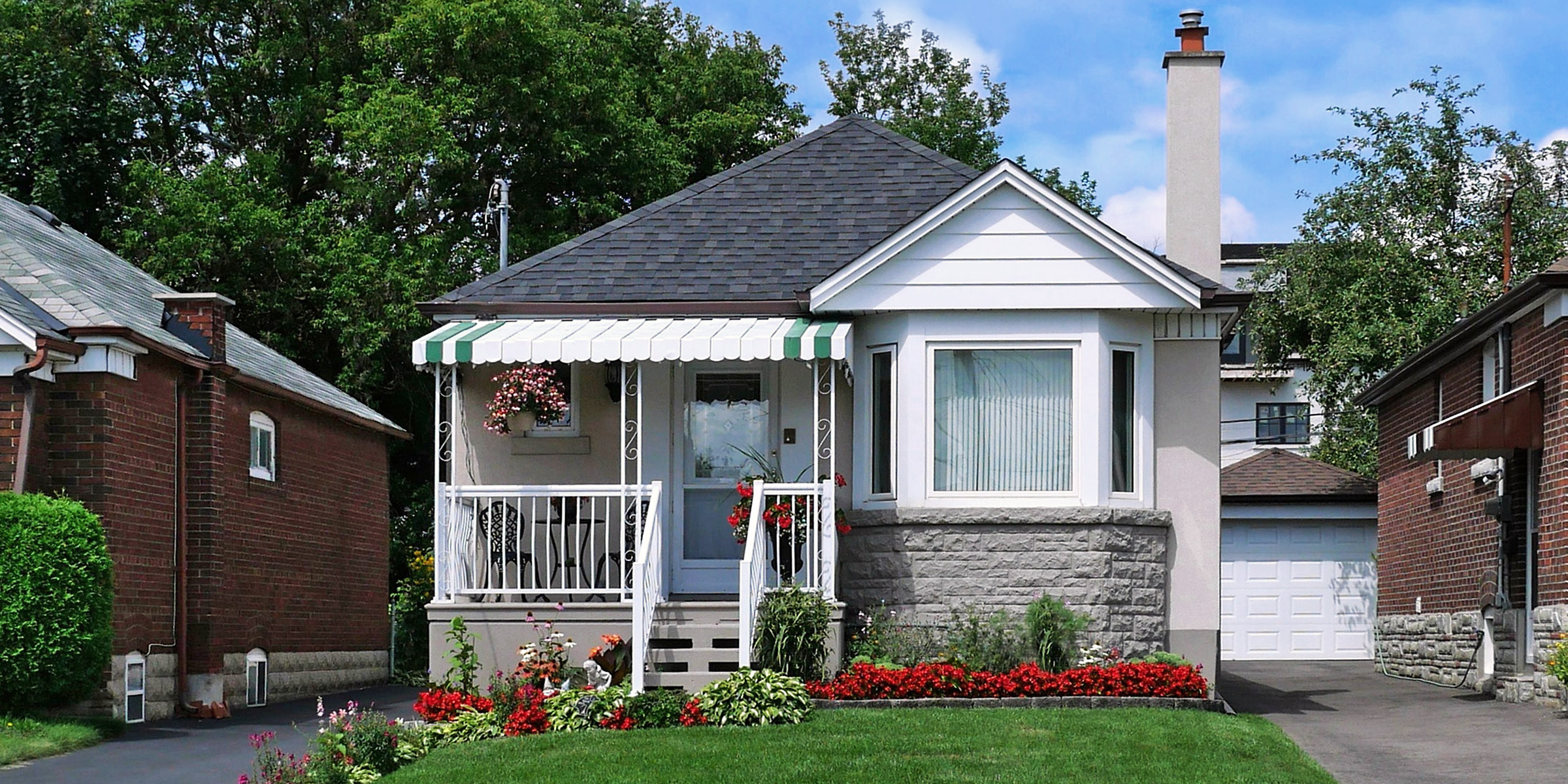 A cozy suburban house nestled between two brick homes | Source: Shutterstock