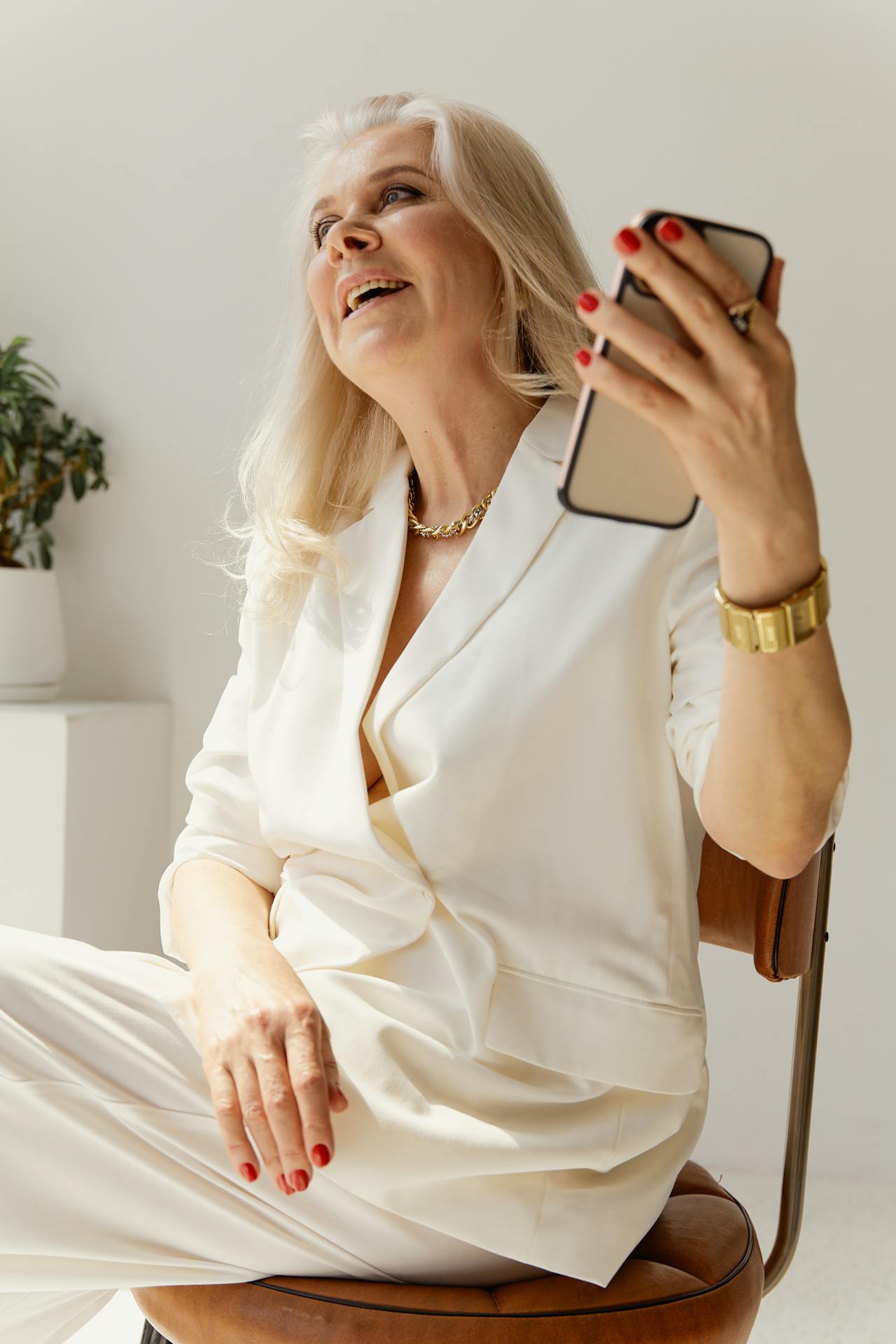 An elderly woman holding her phone | Source: Pexels