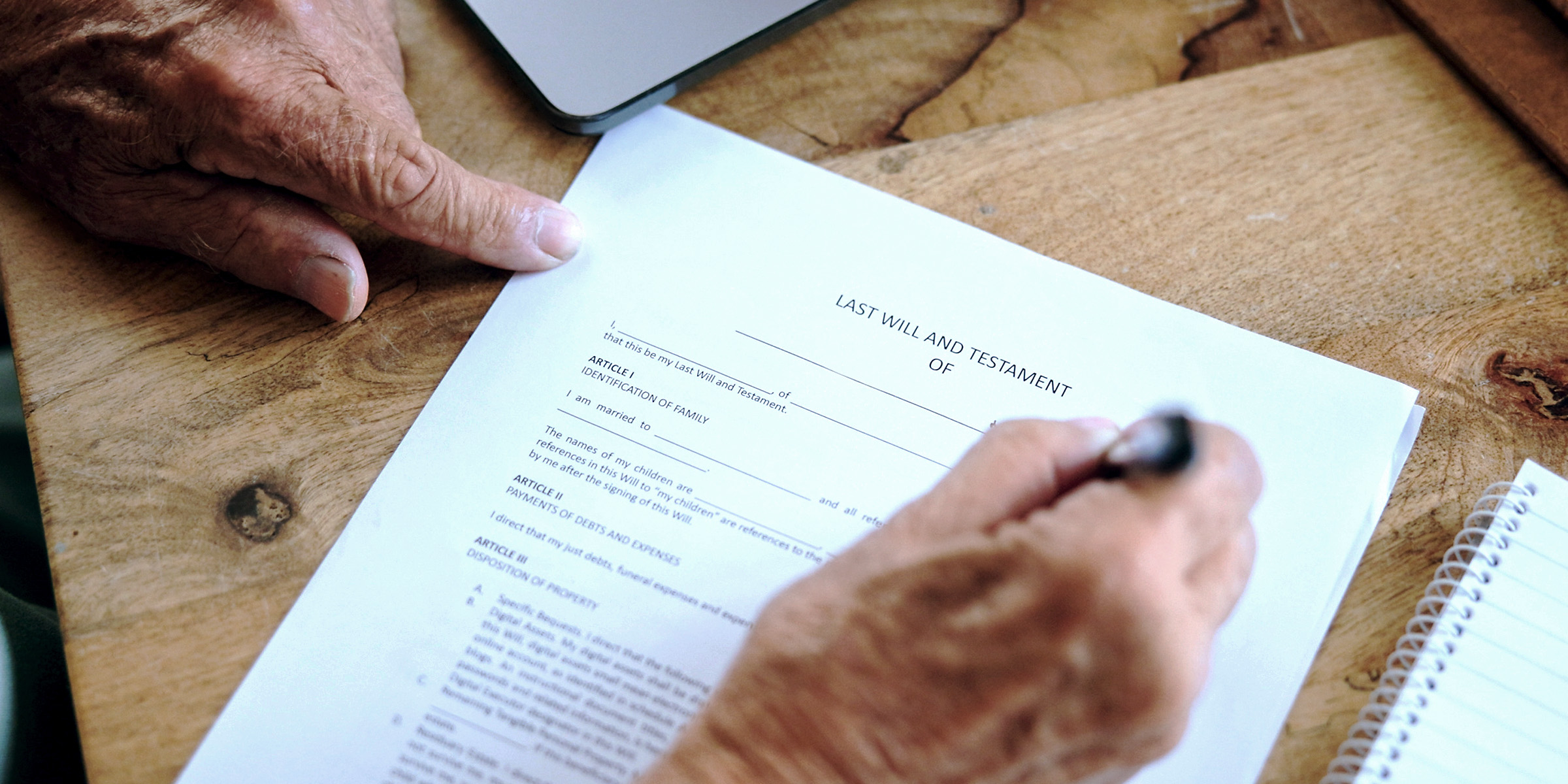 An elderly man signing his last will and testament | Source: Shutterstock