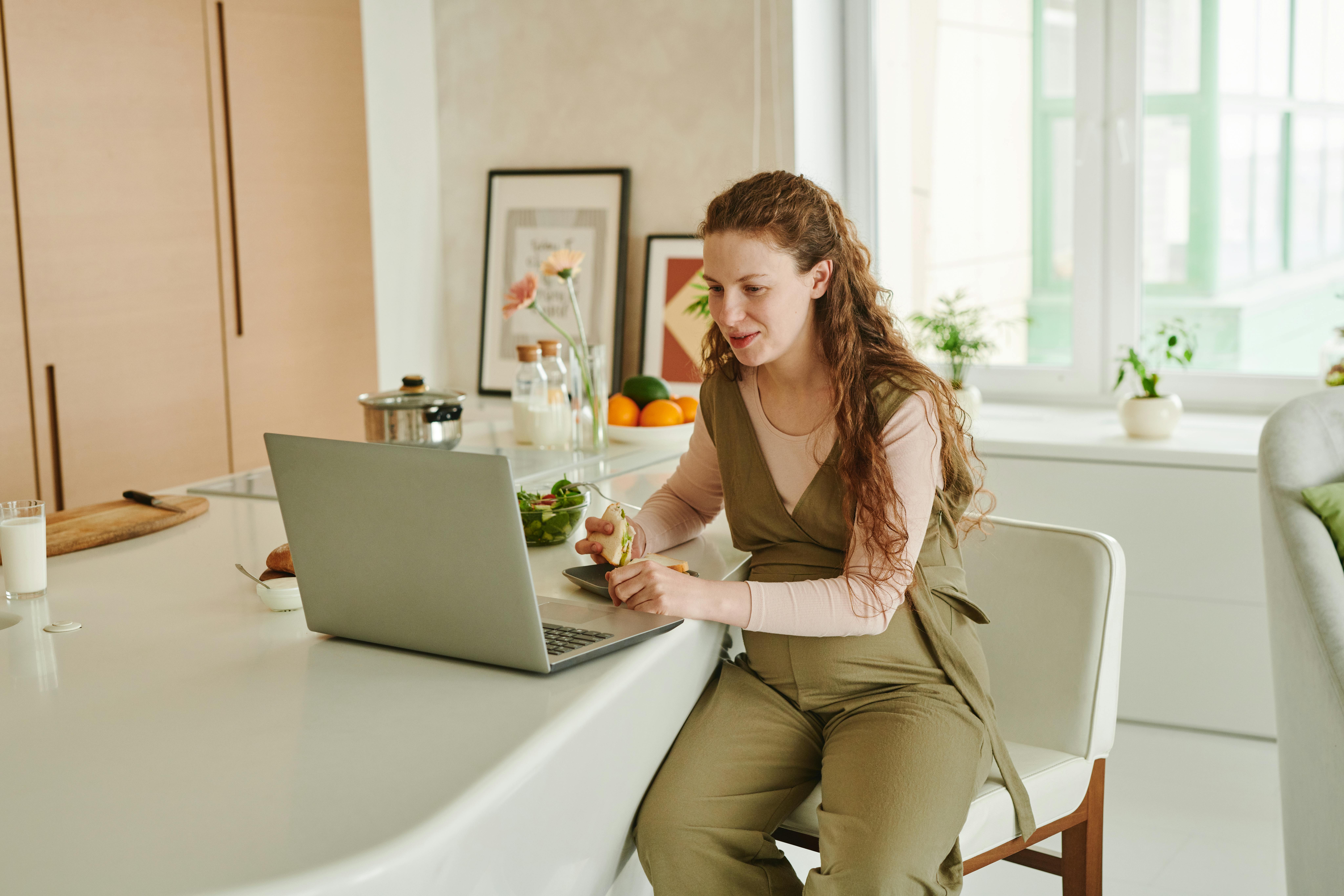 A woman sitting on a chair and using a laptop | Source: Pexels