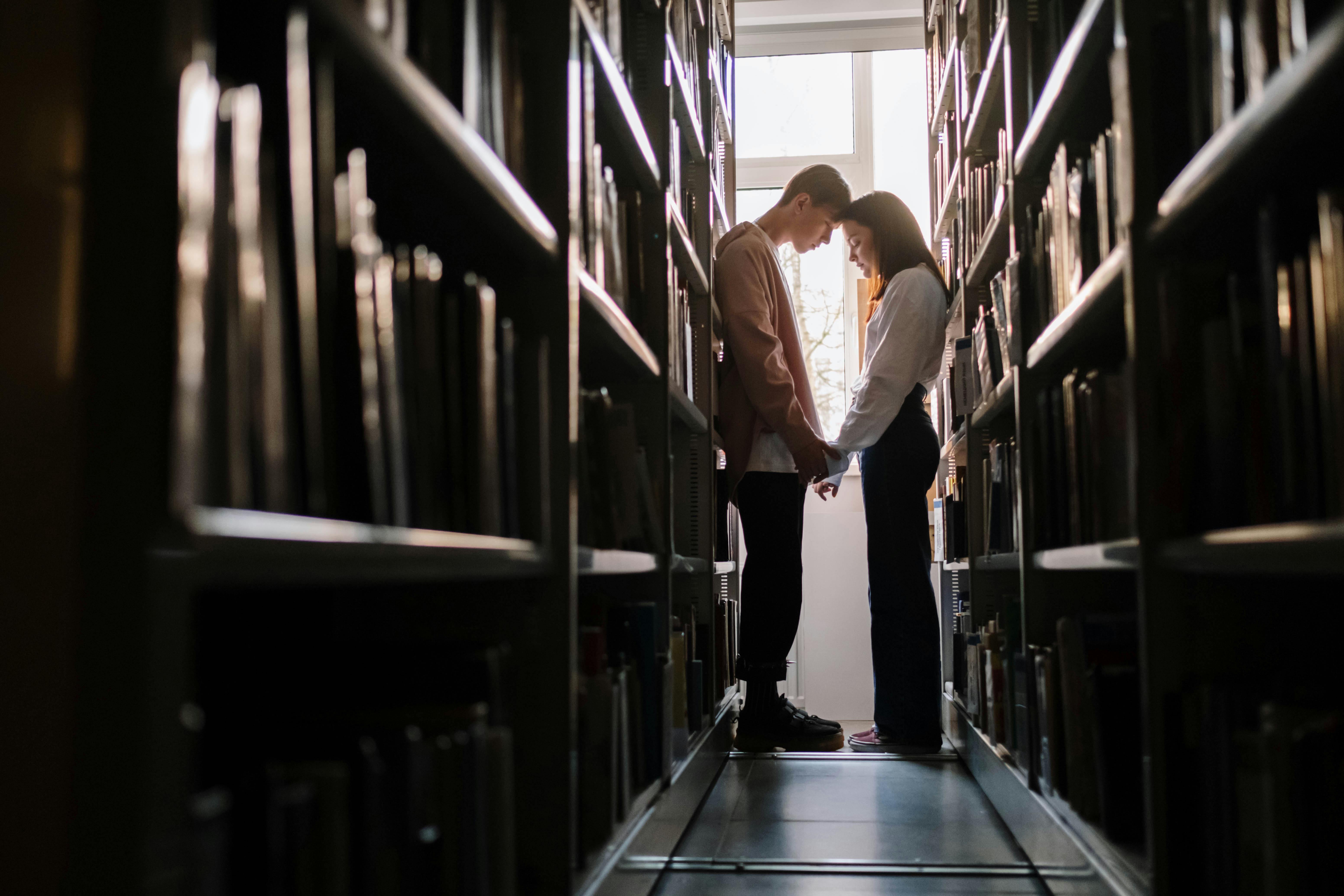 A couple holds hands while in the library | Source: Pexels