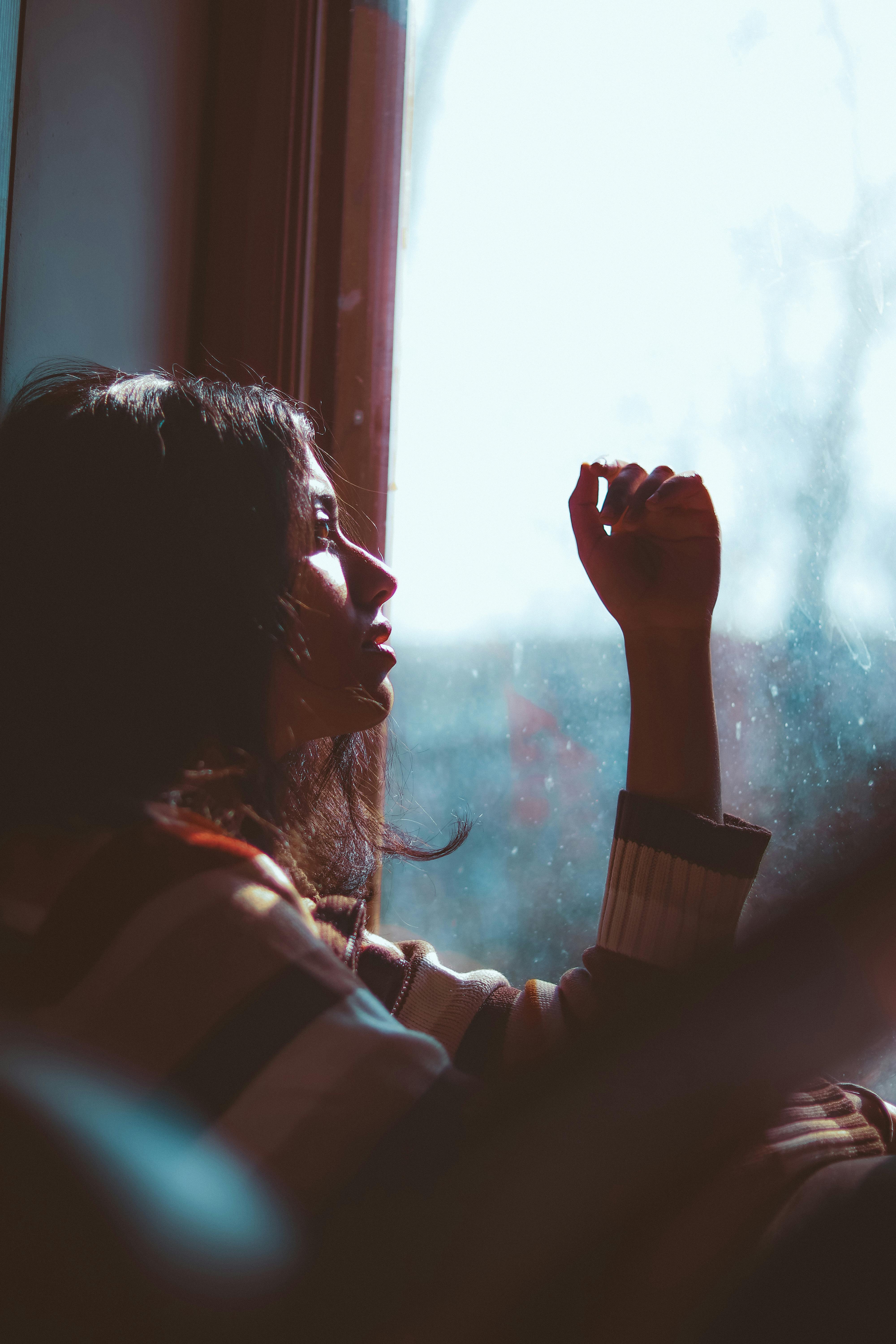 Woman sitting by a window | Source: Pexels
