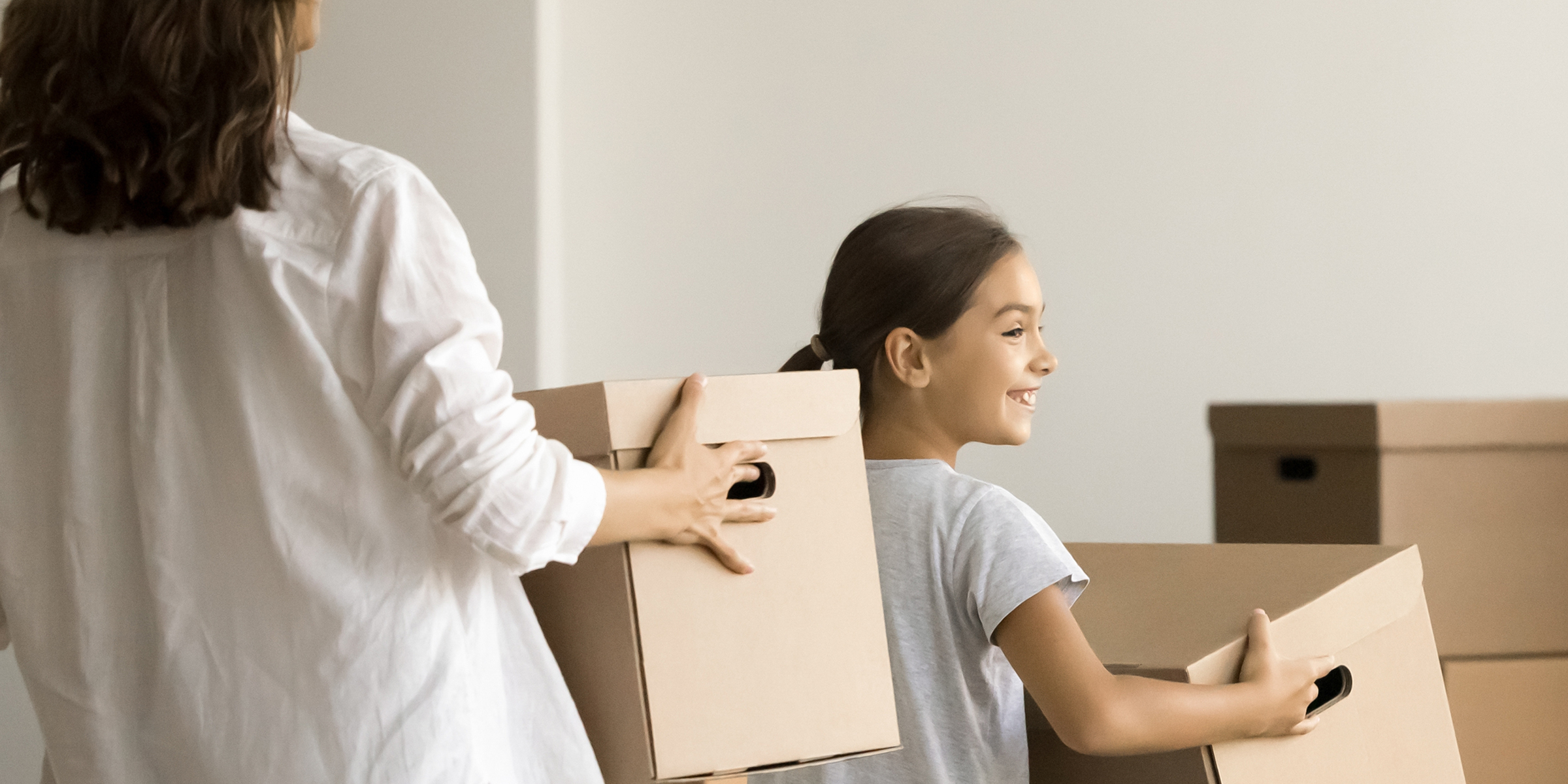 A woman and her daughter holding boxes | Source: Shutterstock
