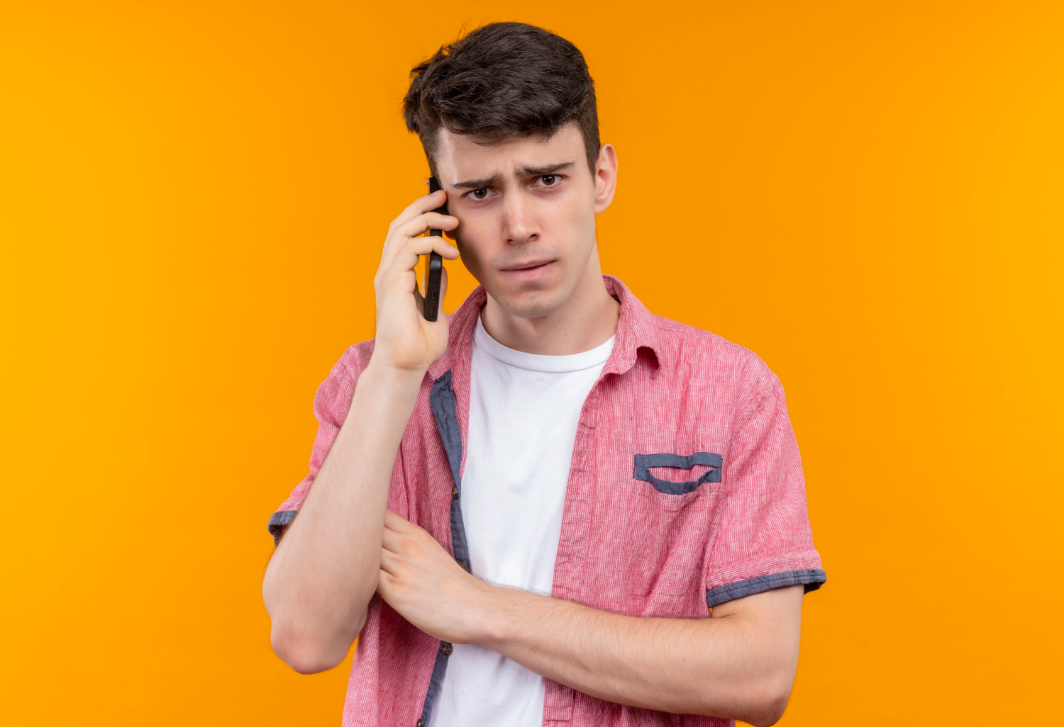 An annoyed young man talking on the phone | Source: Freepik