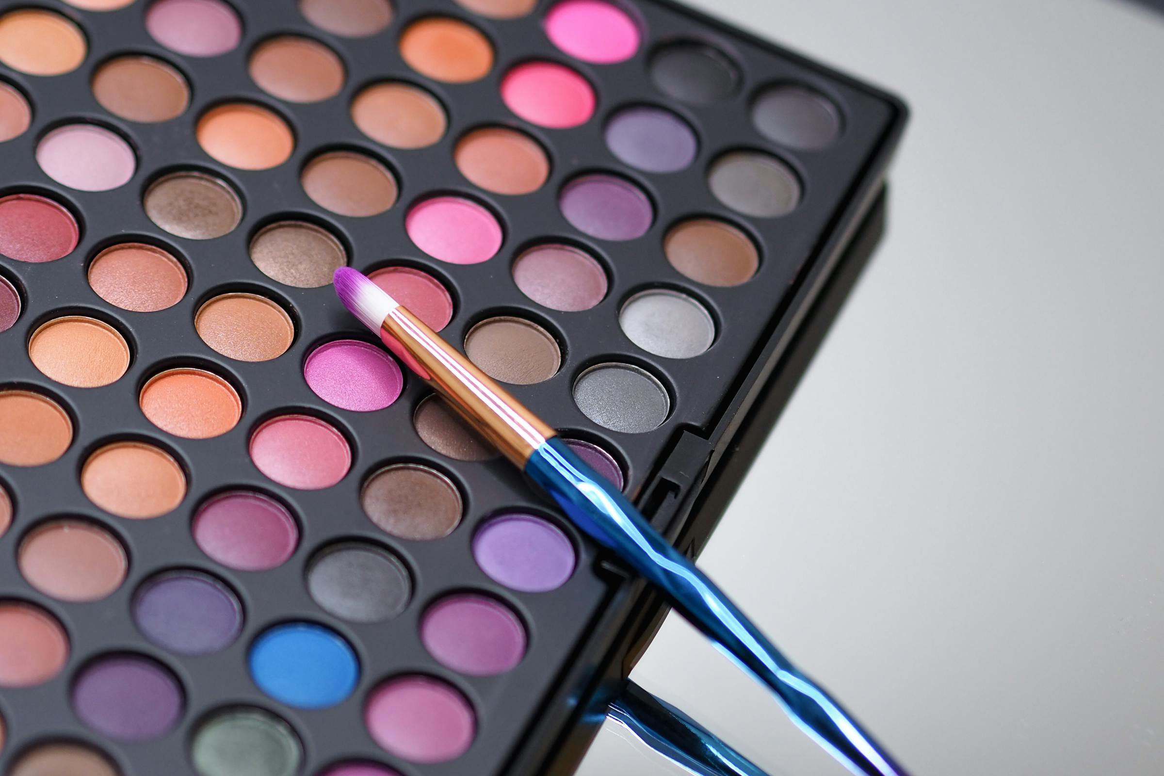 An eyeshadow palette and brush | Source: Pexels