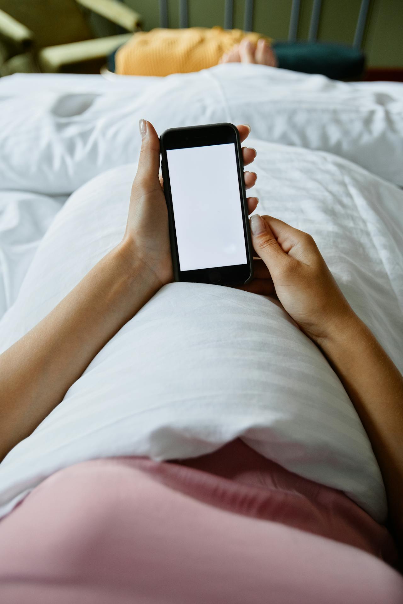 A woman using her phone in bed | Source: Pexels