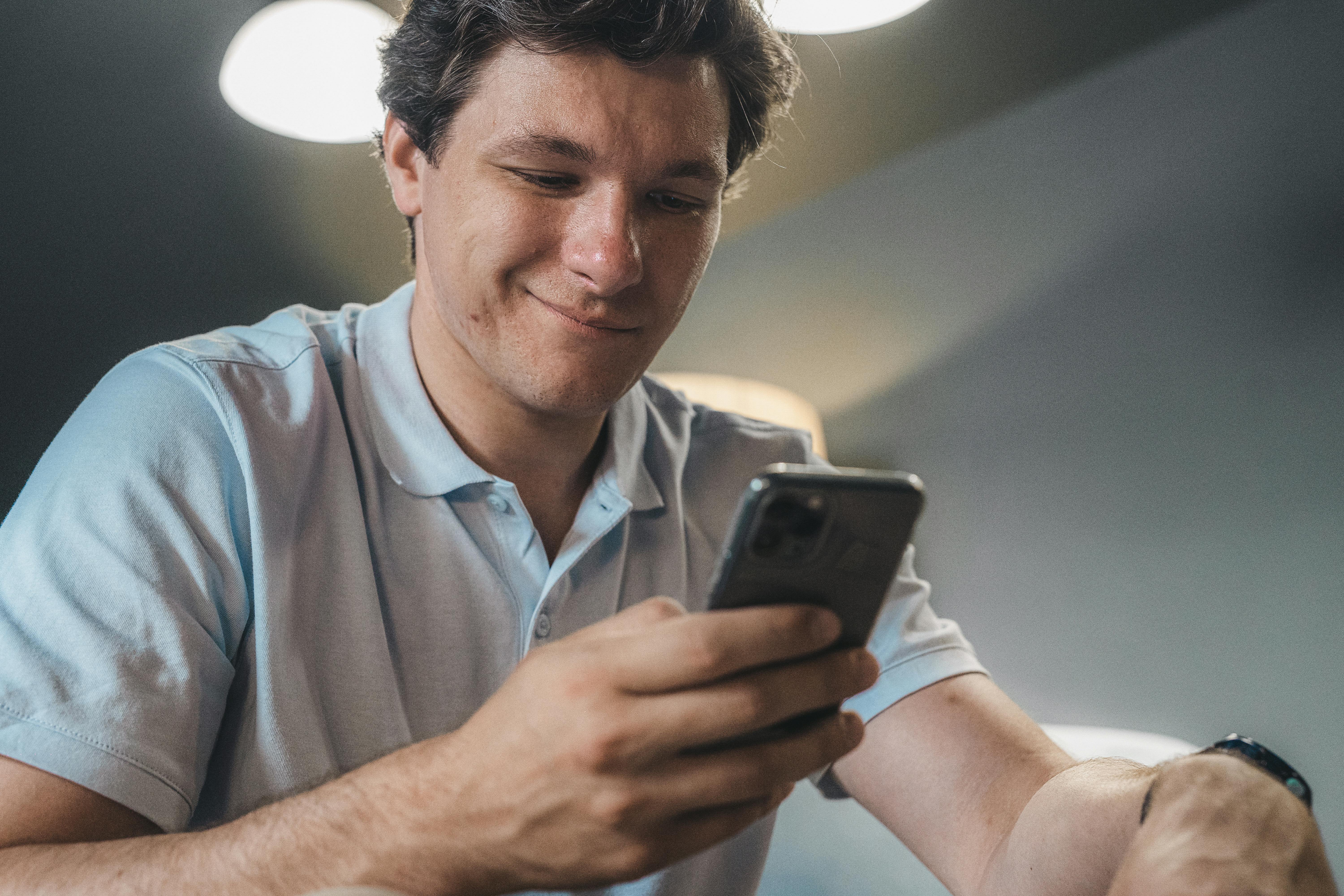A happy man using his phone | Source: Pexels