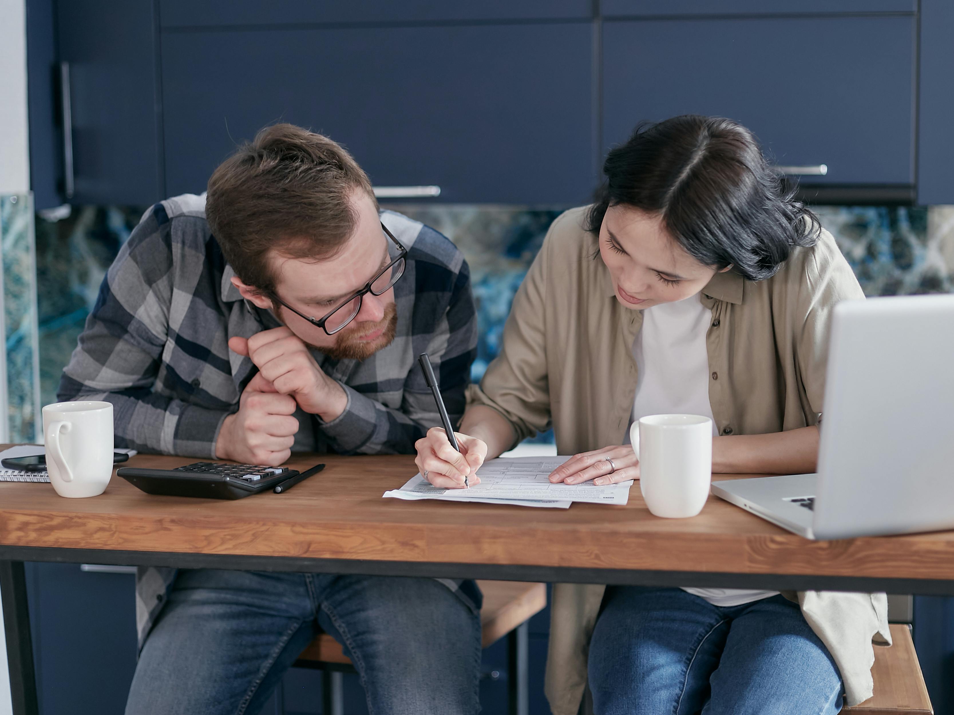 A man looking at a woman writing on a document | Source: Pexels