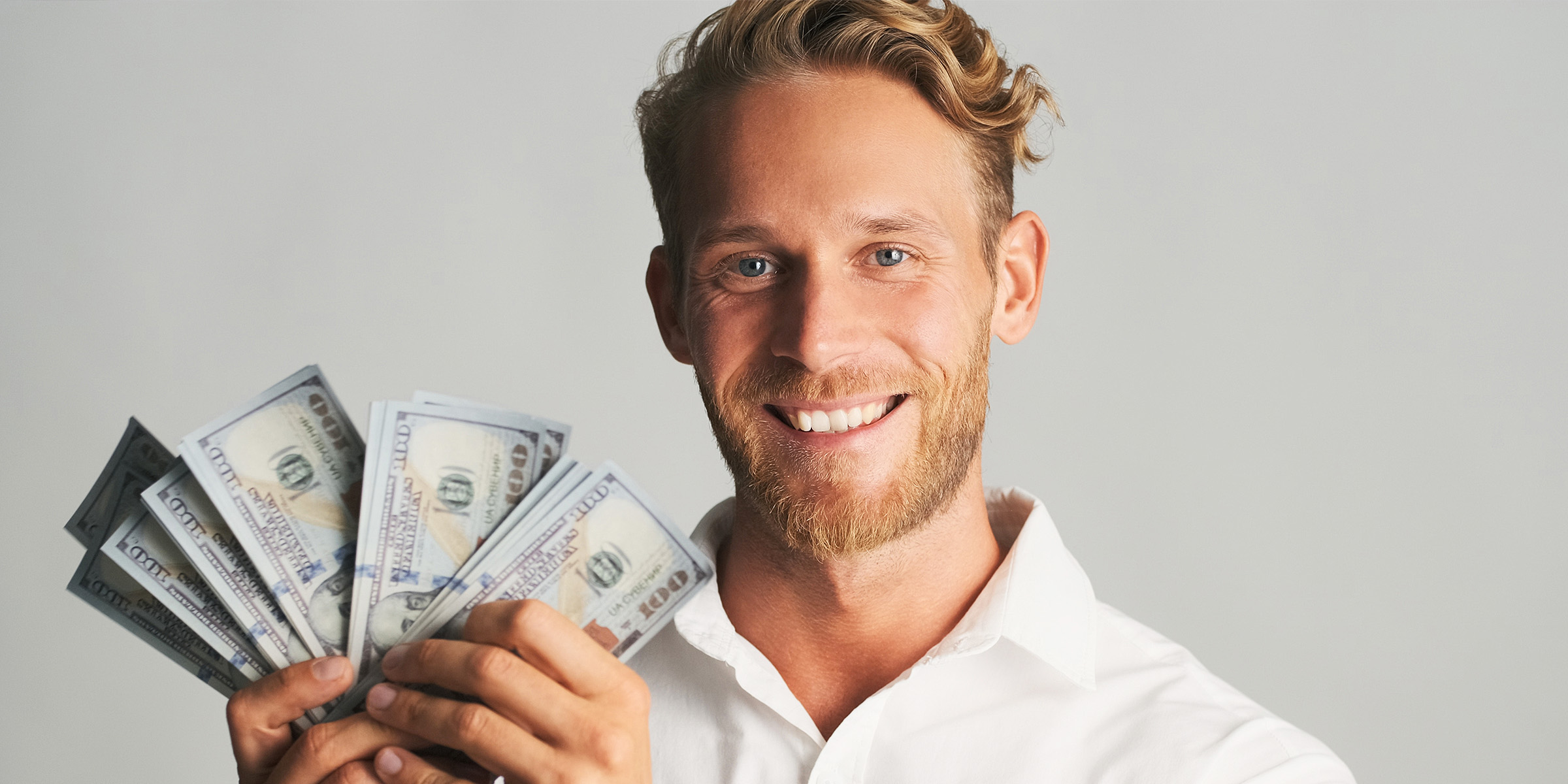 A man holding dollar bills | Source: Freepik