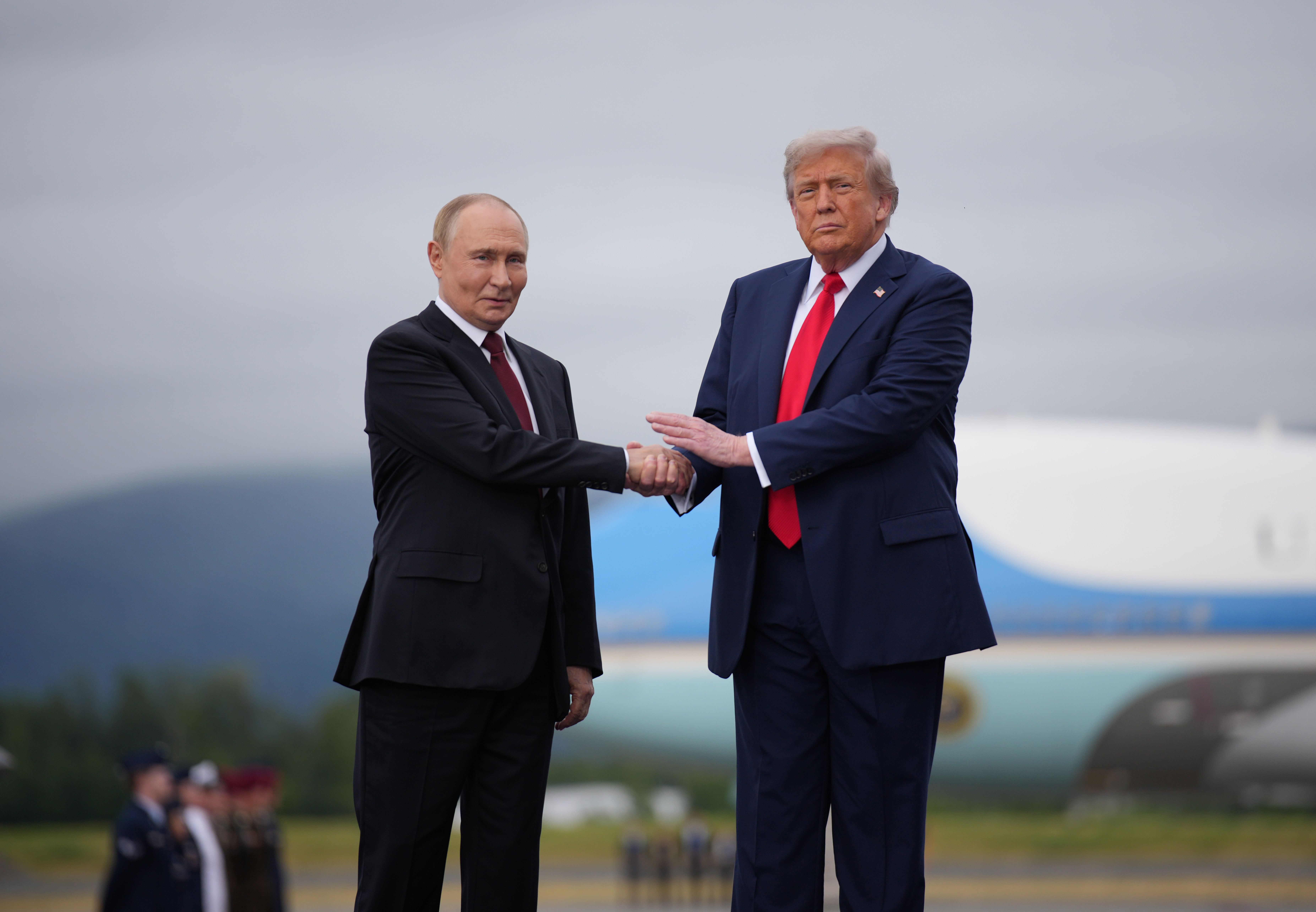 U.S. President Donald Trump (R) greets Russian President Vladimir Putin as he arrives at Joint Base Elmendorf-Richardson on August 15, 2025, in Anchorage, Alaska. | Source: Getty Images